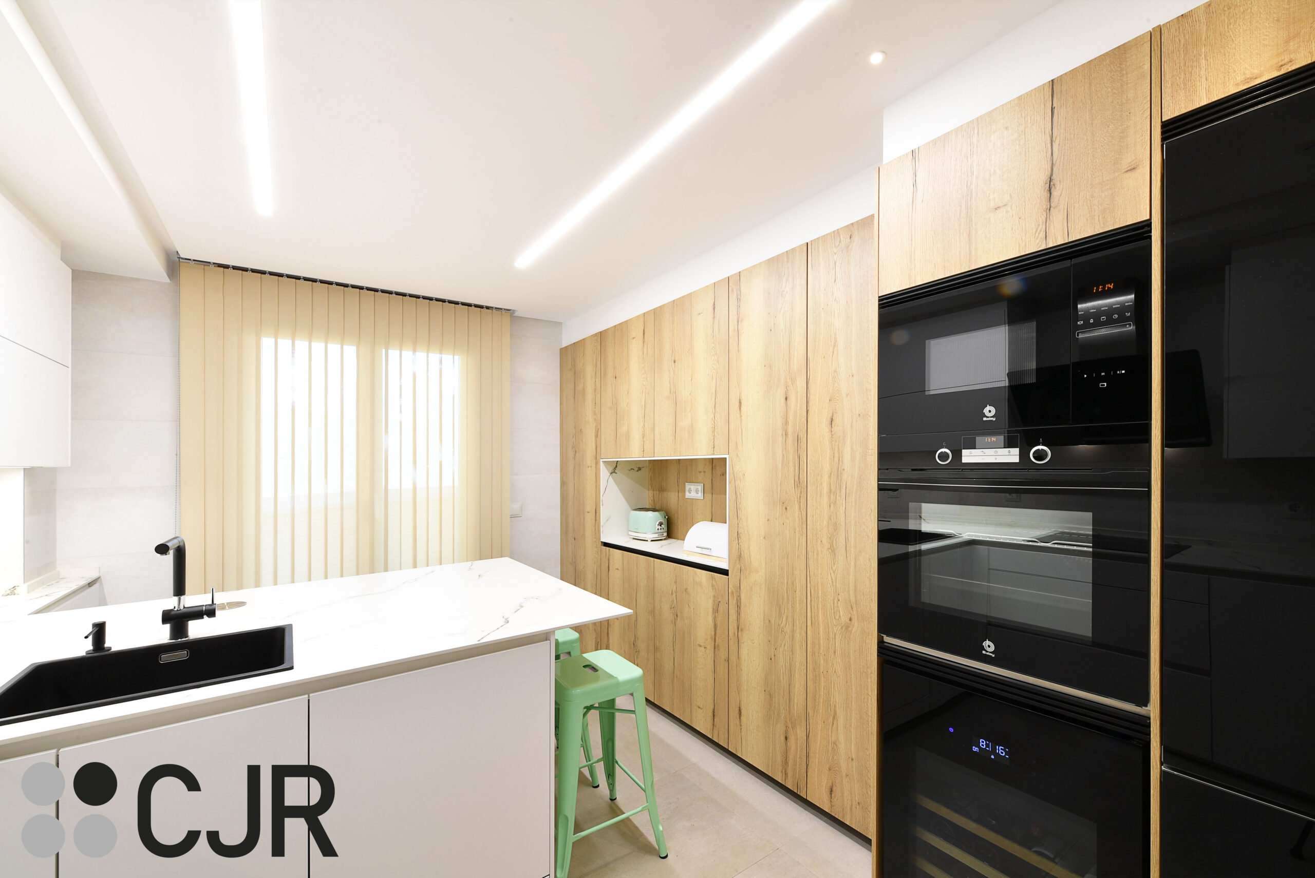 cocina blanca y madera con electrodomesticos en cristal negro