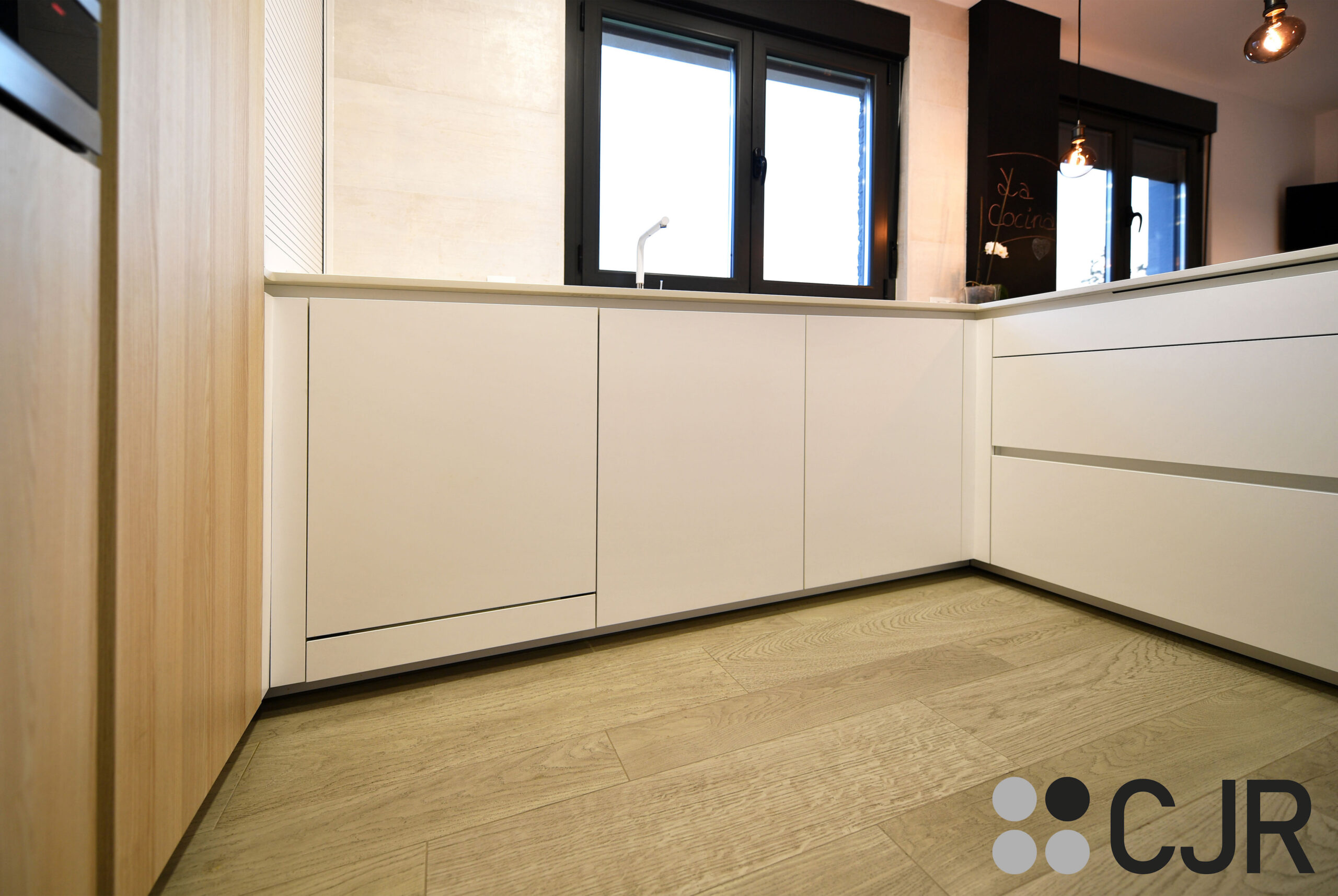 cocina blanca y madera abierta al salon con peninsula en dekton uyuni cjr
