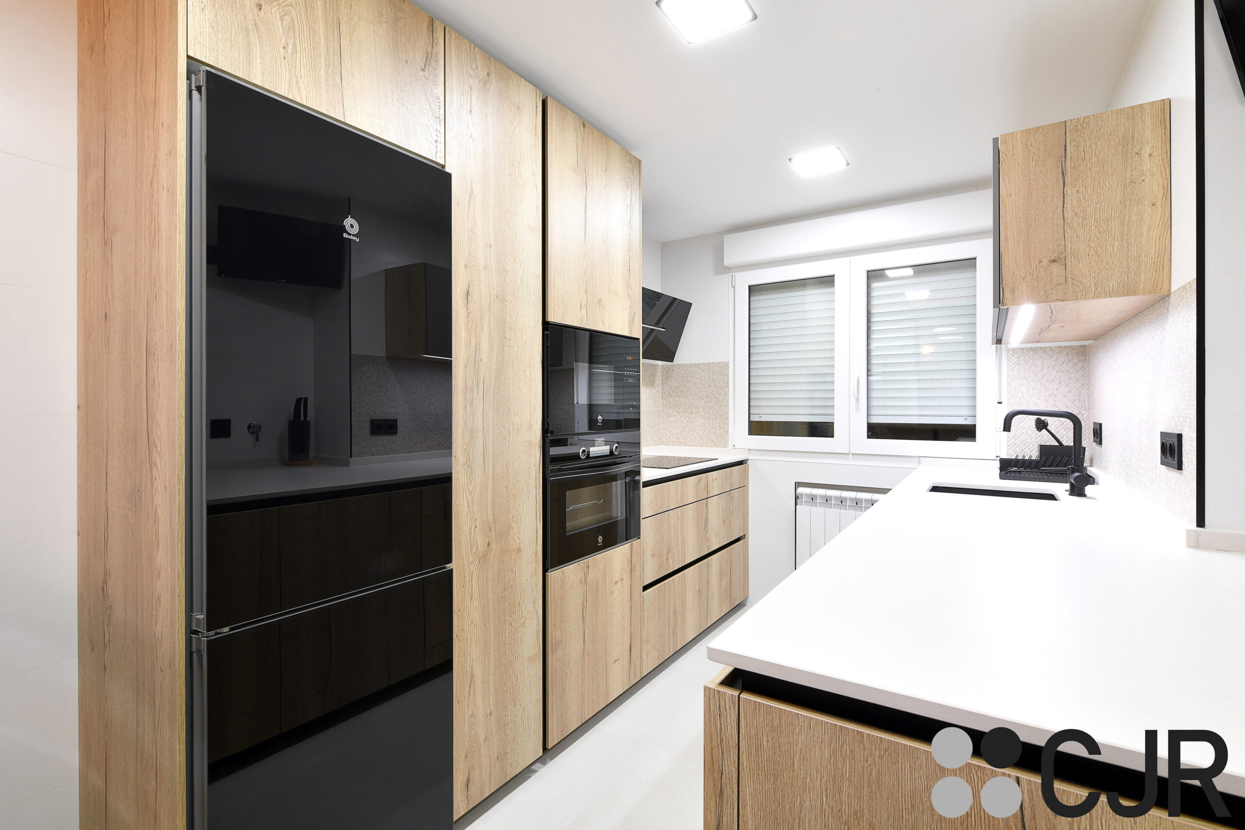 cocina blanca y madera con electrodomesticos en negro cjr