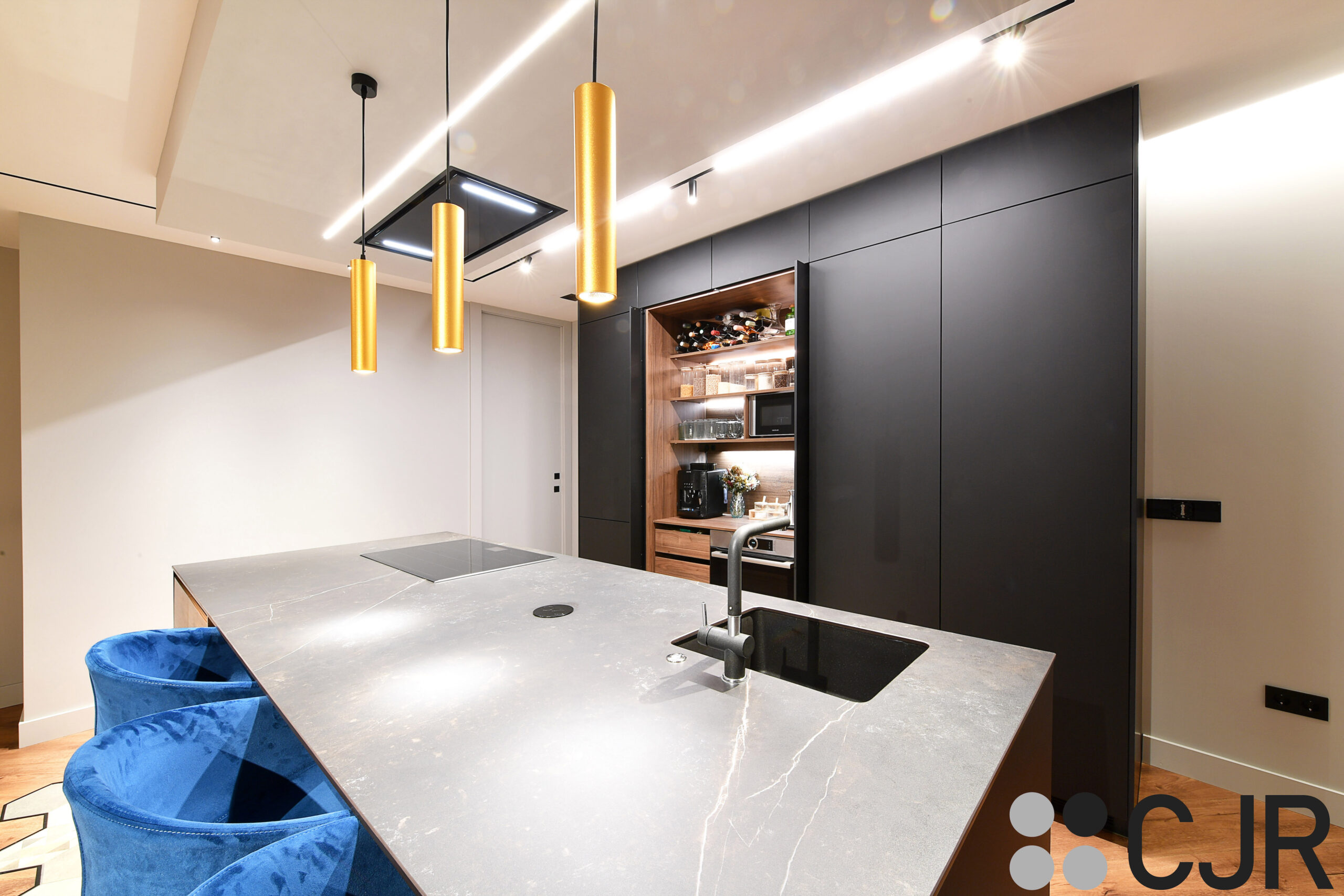 cocina negra y madera con isla encimera dekton kelya cjr