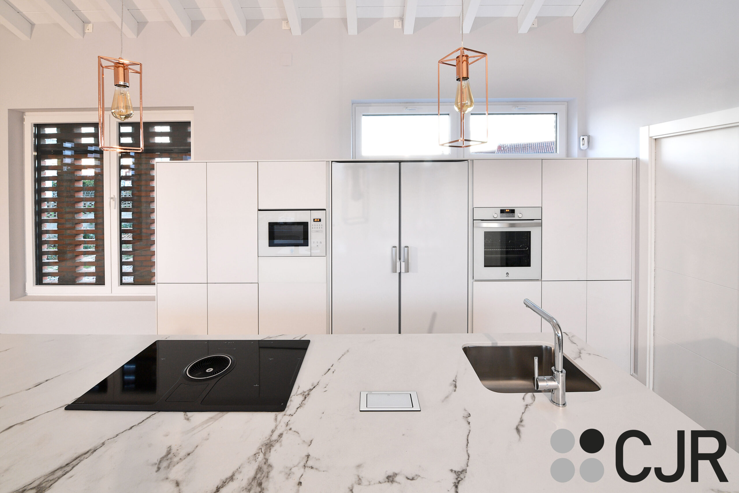 cocina blanca con placa nikolatesla y encimera dekton kairos cjr