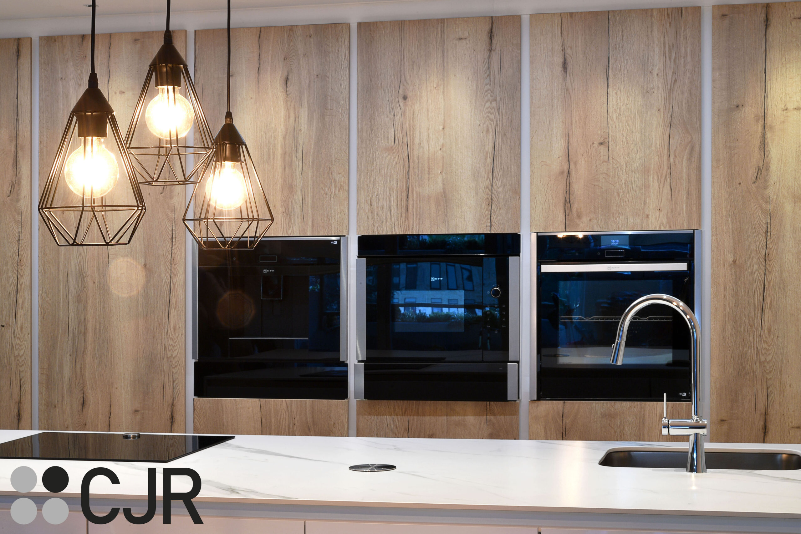 cocina madera y blanca con electrodomesticos neff en negro cjr