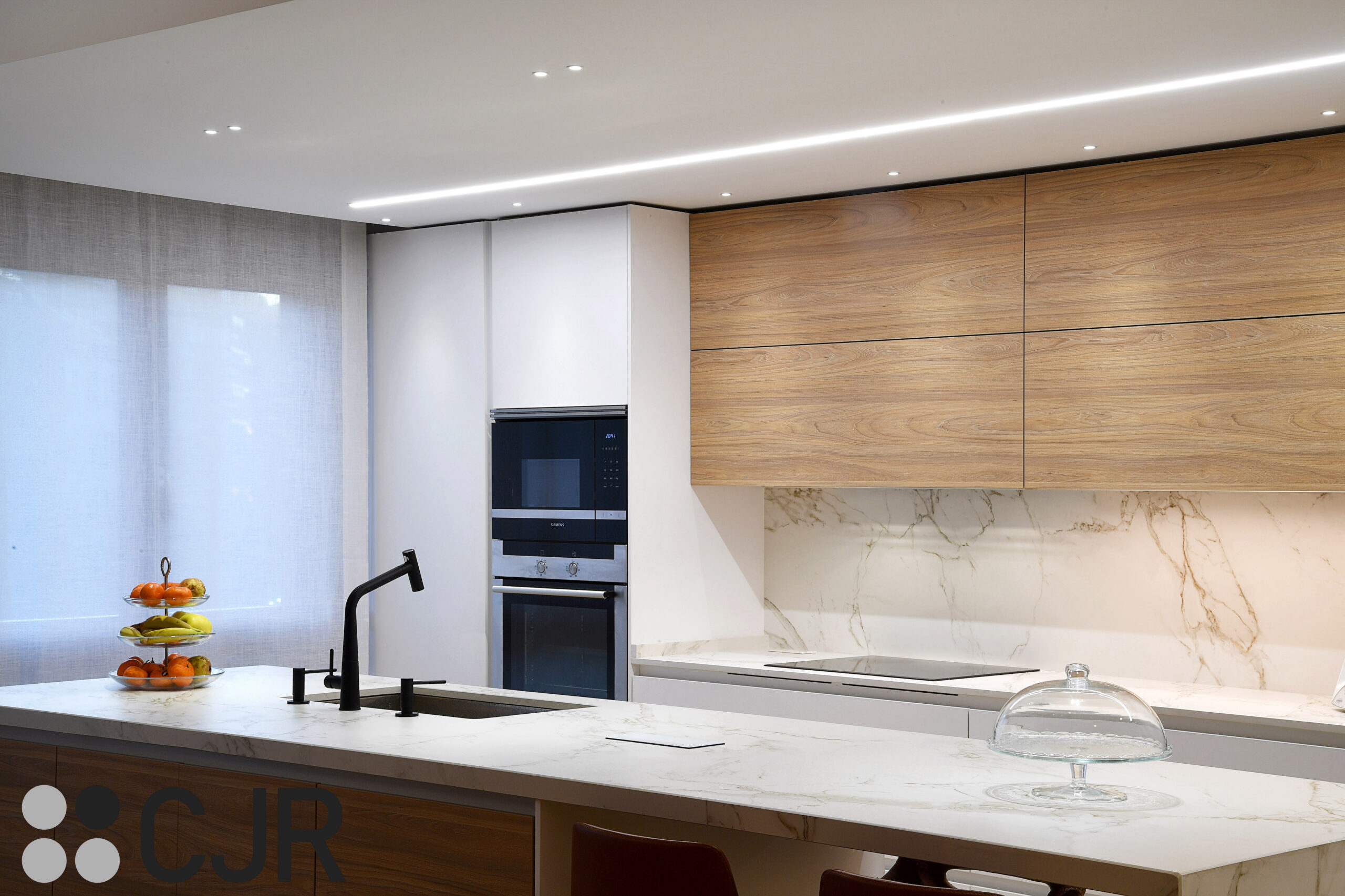 cocina con isla moderna blanca y madera cjr