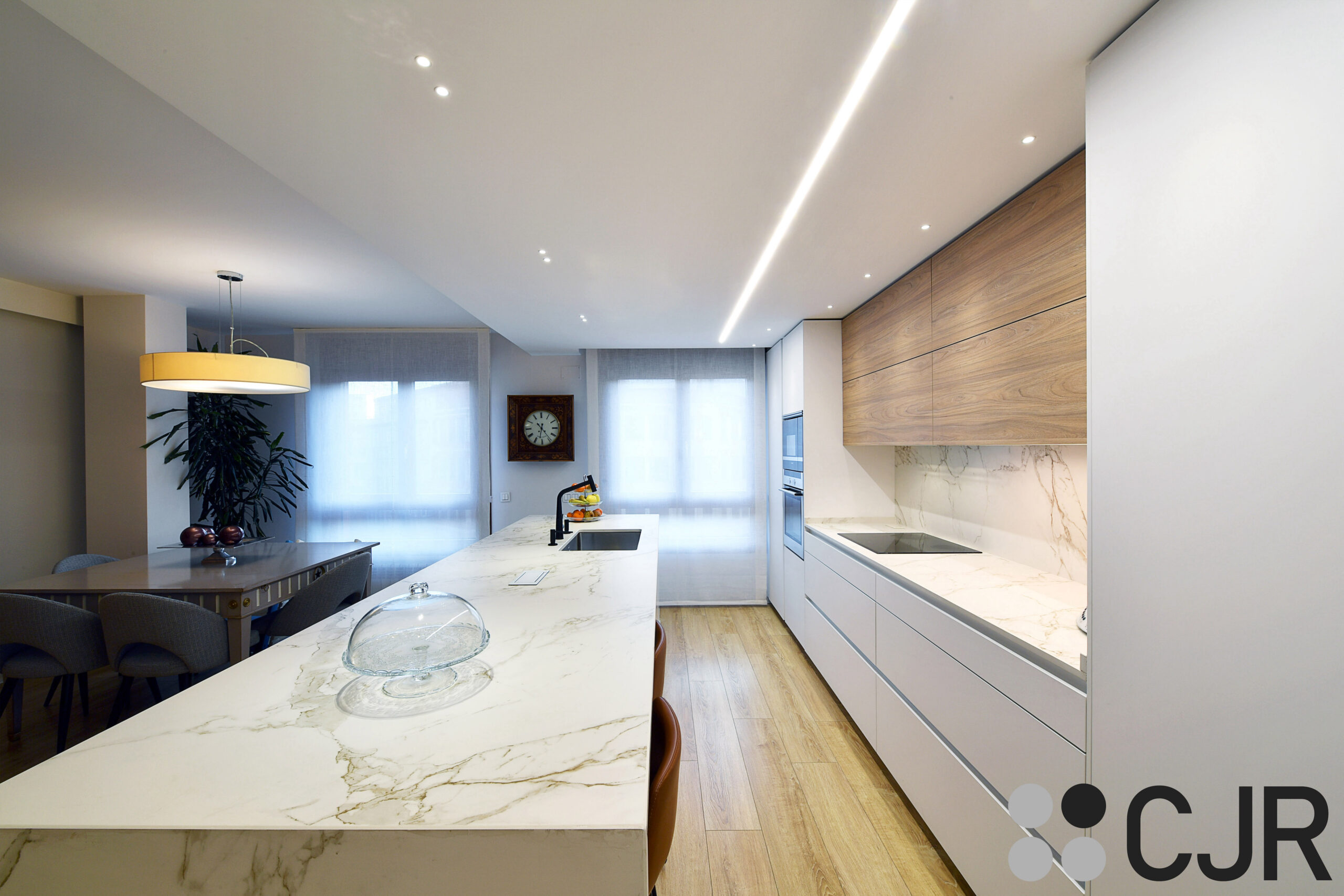 cocina moderna con isla blanca y madera cjr