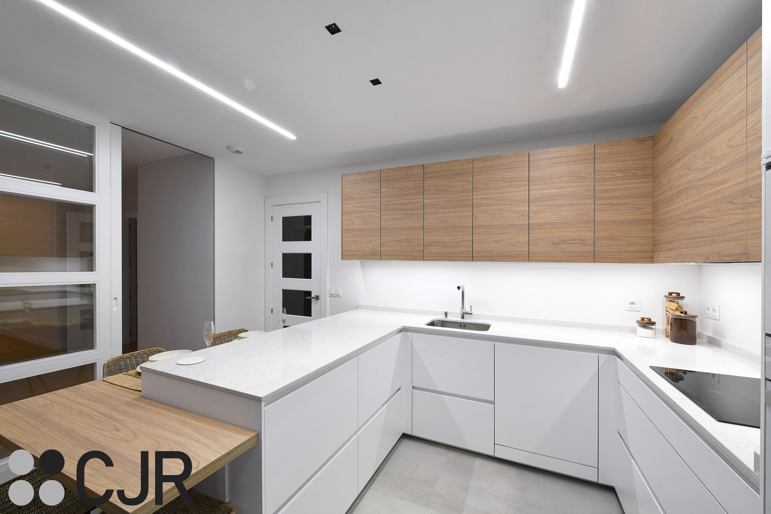 cocina moderna con peninsula en blanco mate y madera cjr