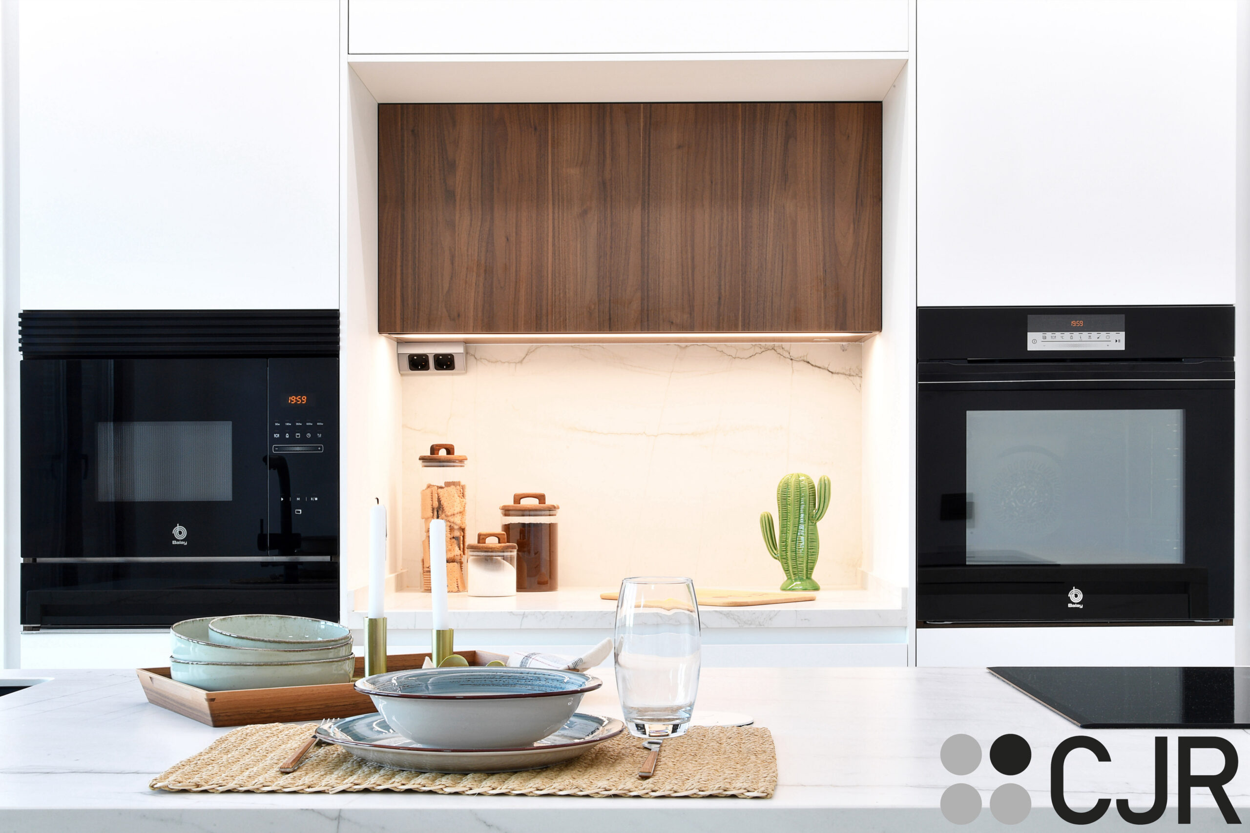 cocina moderna blanca mate con desayunador iluminado y mueble alto en madera nogal cjr