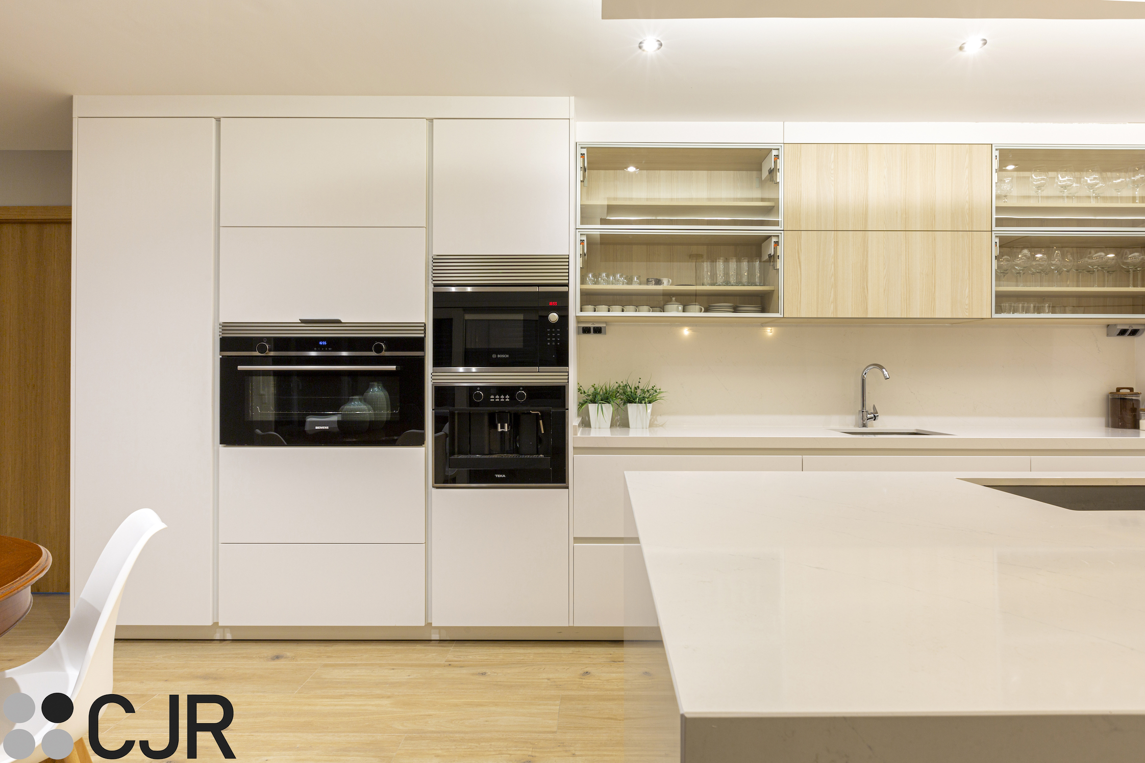 cocina moderna blanca y madera con electrodomesticos en negro cjr