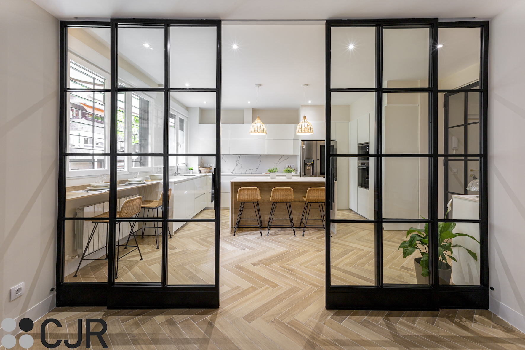 cocina abierta al salón con puerta corredera de hierro lacado negro y cristal cjr