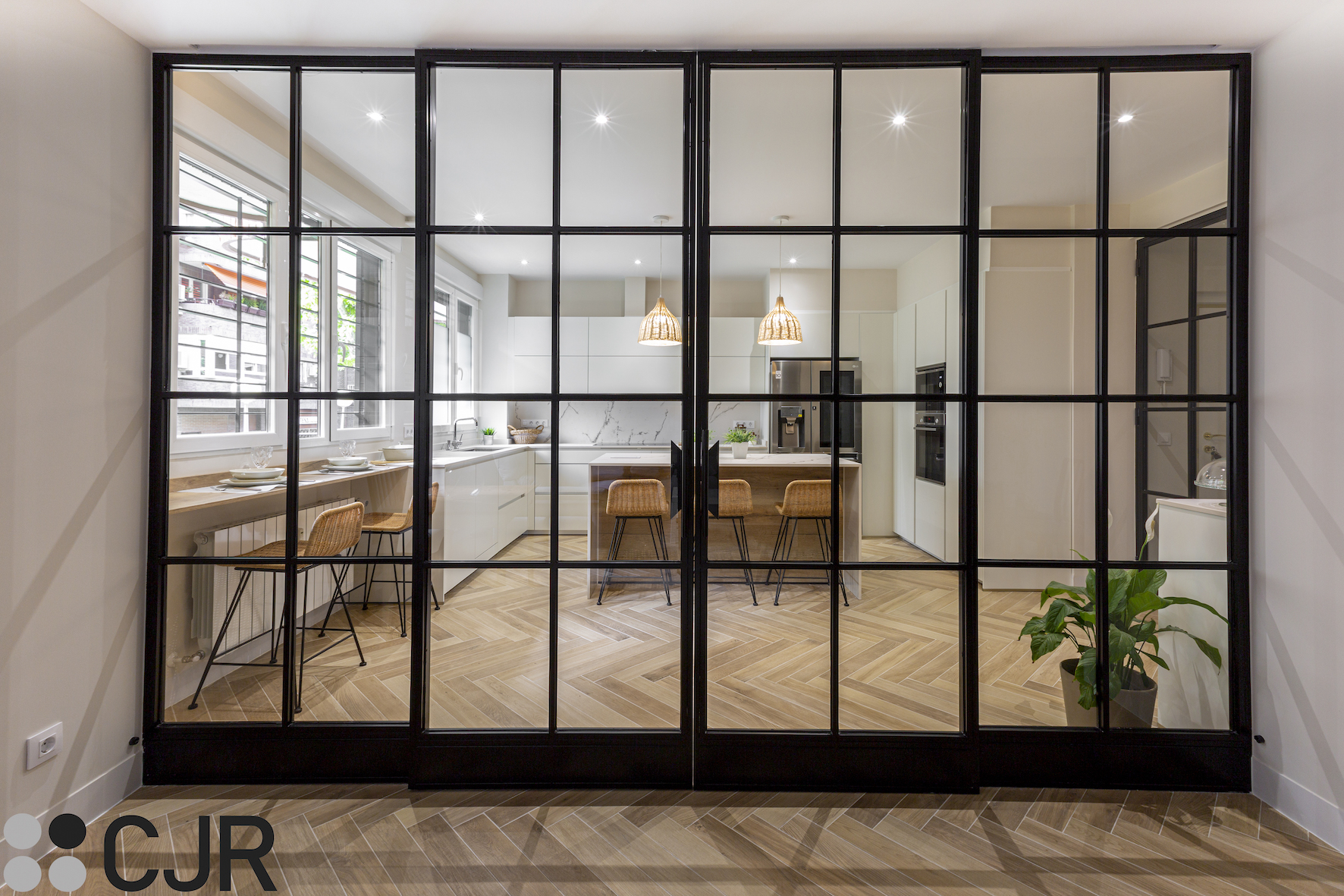 cocina semiabierta al salón con separación de cristal y hierro negro cjr