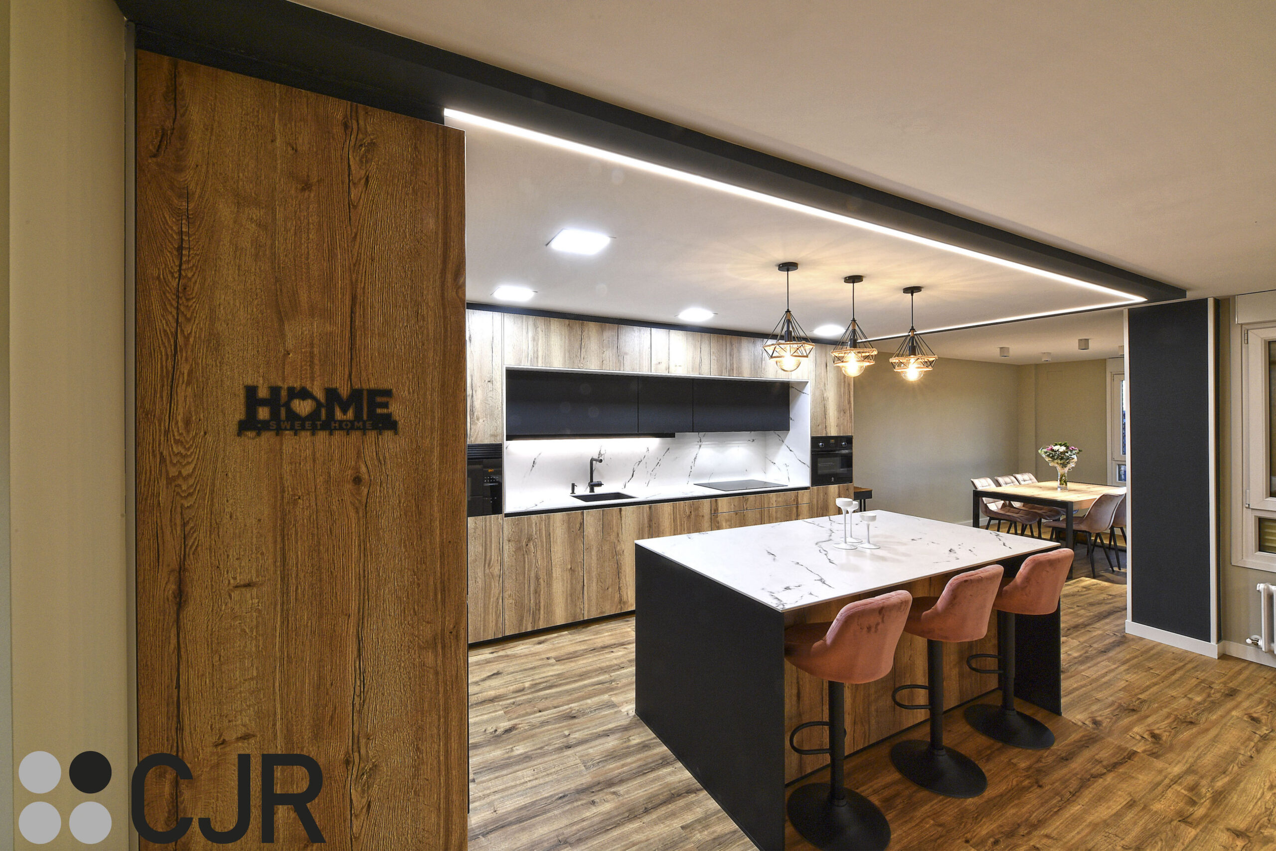 cocina abierta al salon con isla en negro mate, madera y dekton kairos cjr