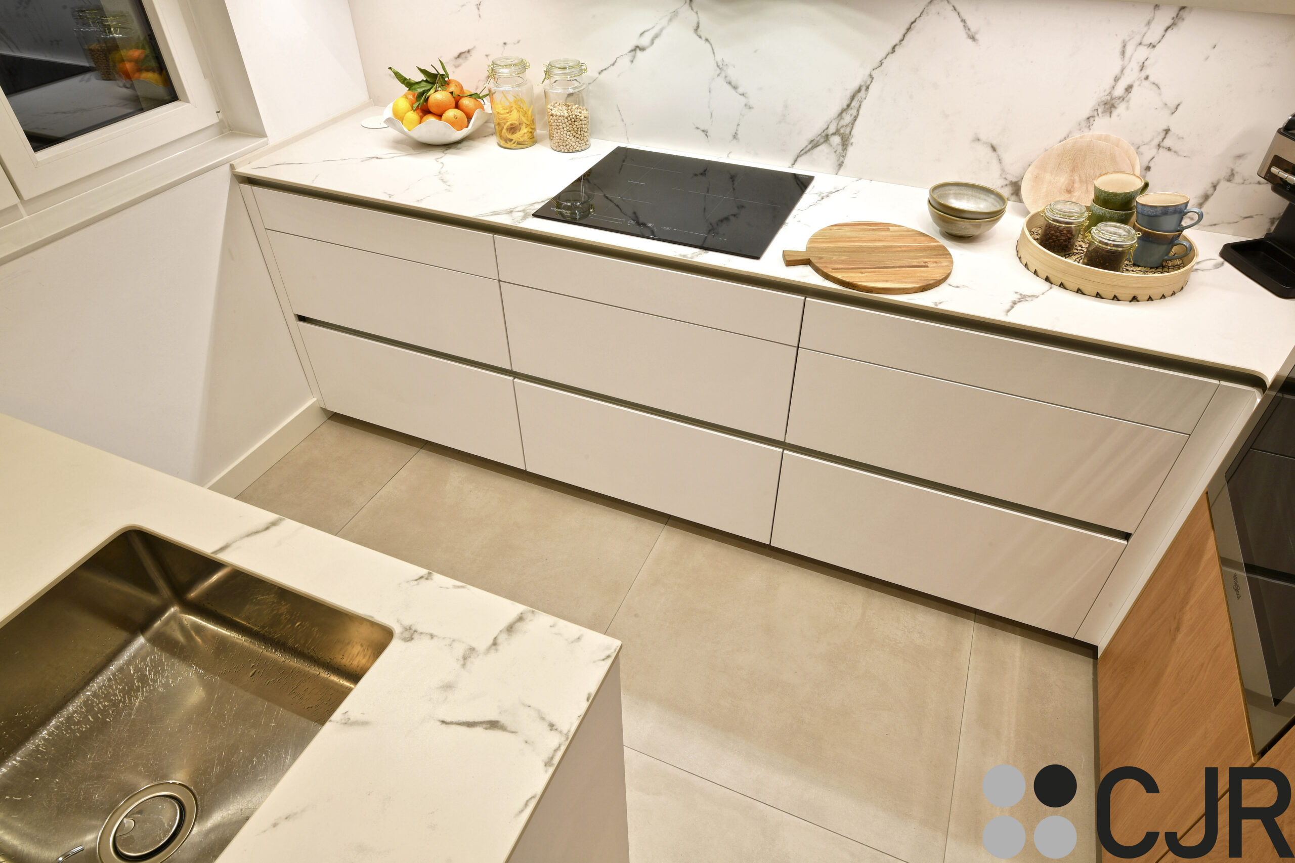 Cocina blanca y madera pequeña con peninsula Dekton Kairos cocinas cjr