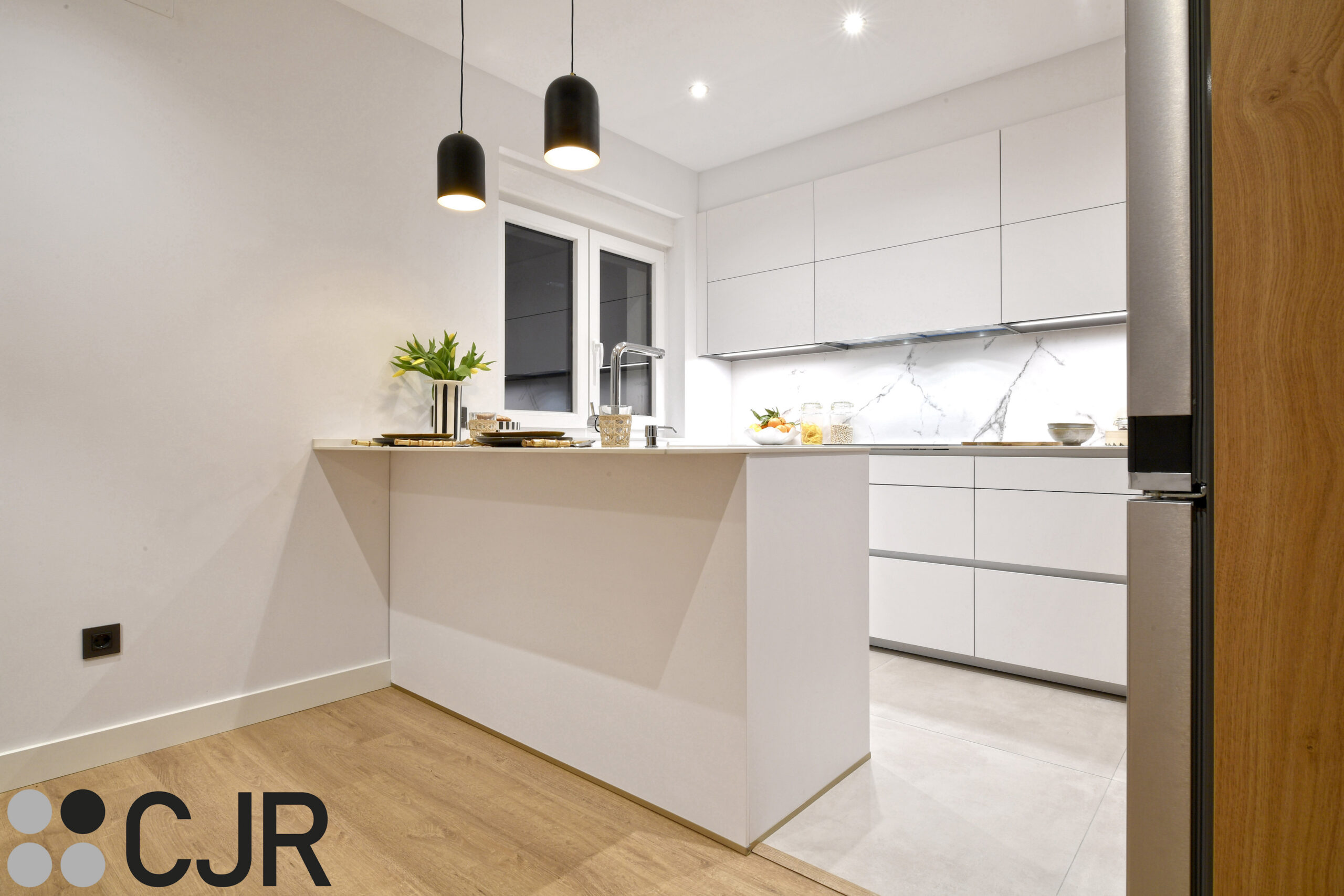 Cocina pequeña blanca dekton kairos en U con mesa CJR