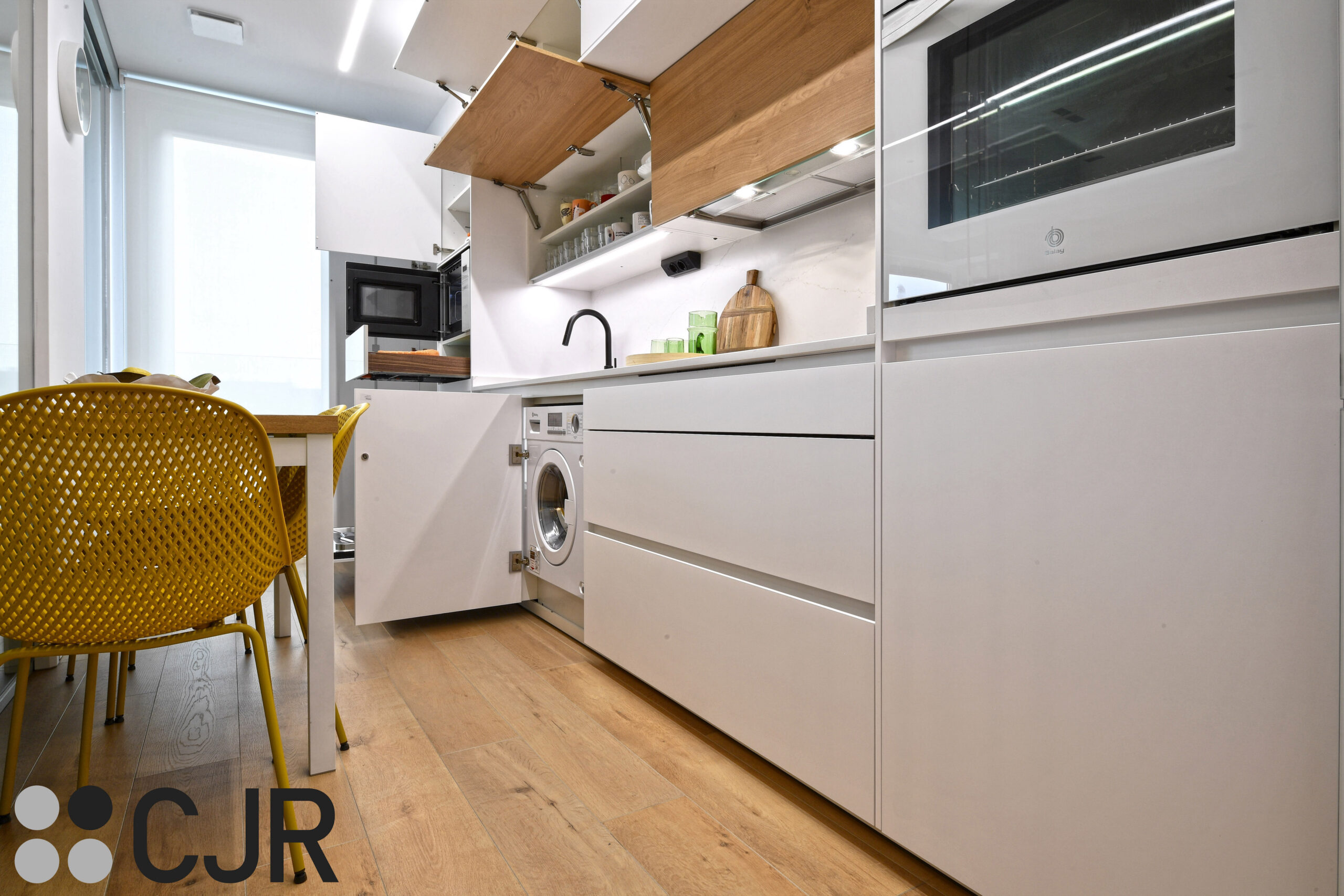 lavadora integrada en la cocina blanca y madera semiabierta cocinas cjr