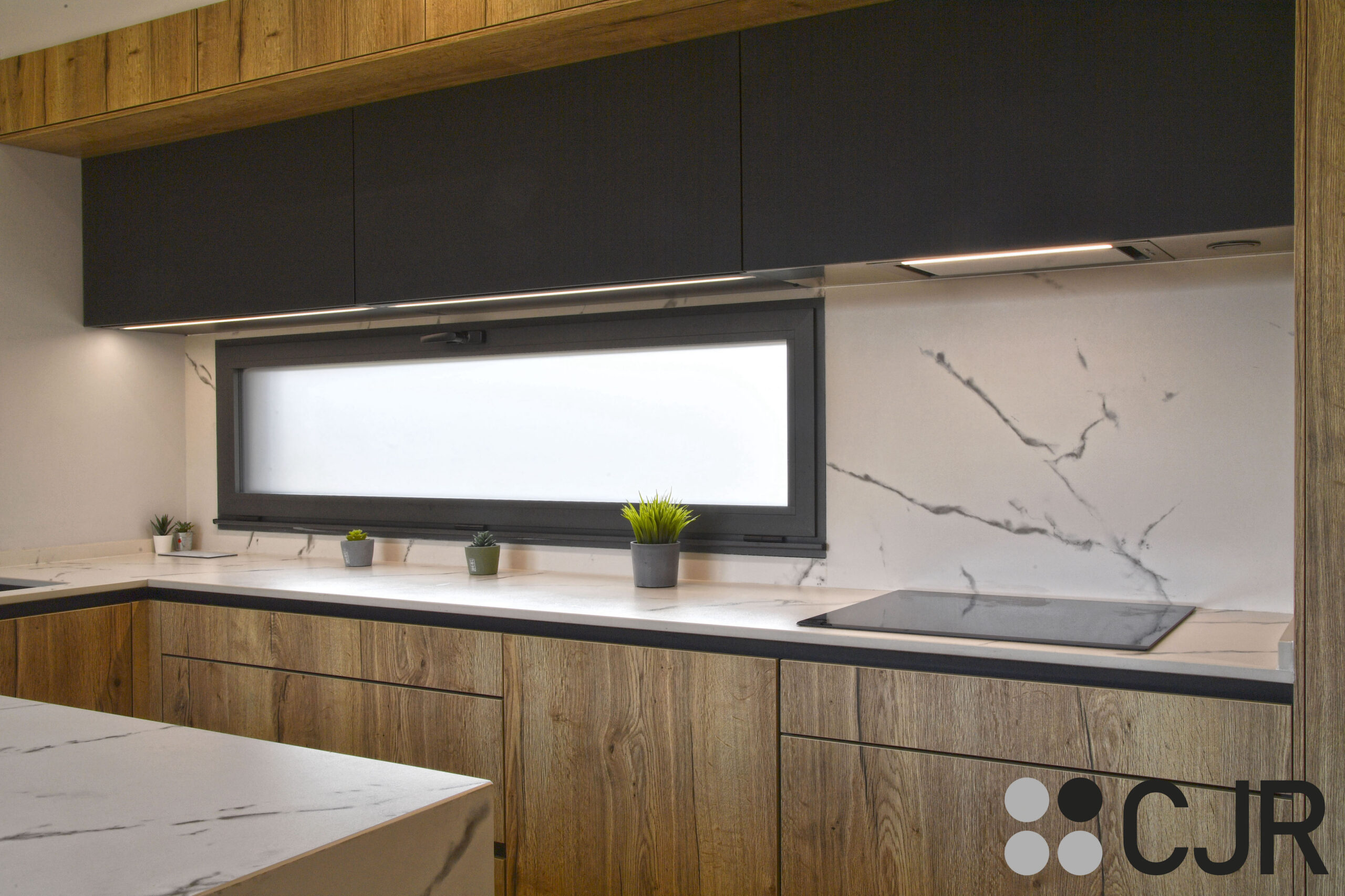 cocina puente con ventana en madera y negro con encimera dekton kairos cocinas cjr