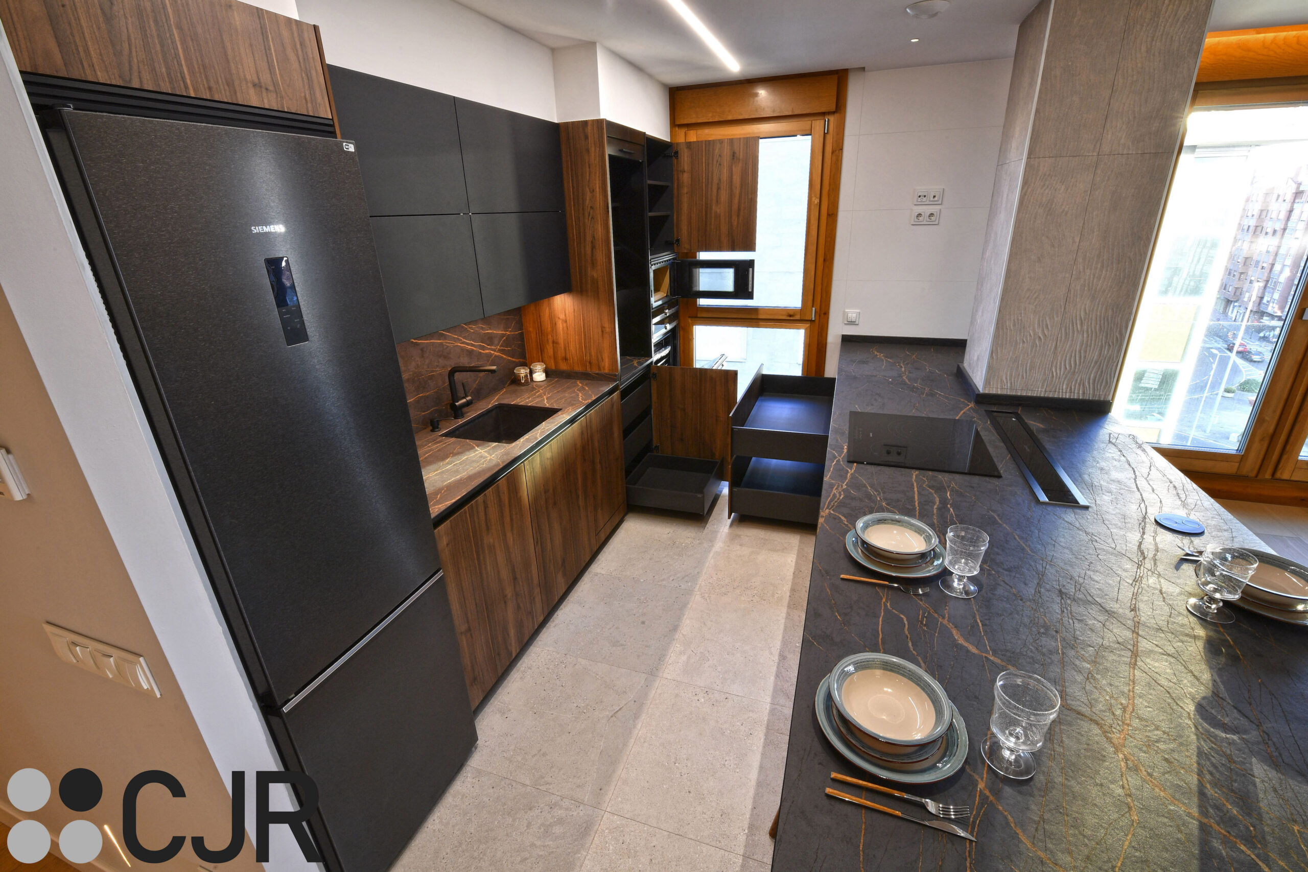 cocina abierta al salon con muebles bajos de cocina en madera y negro cocinas cjr