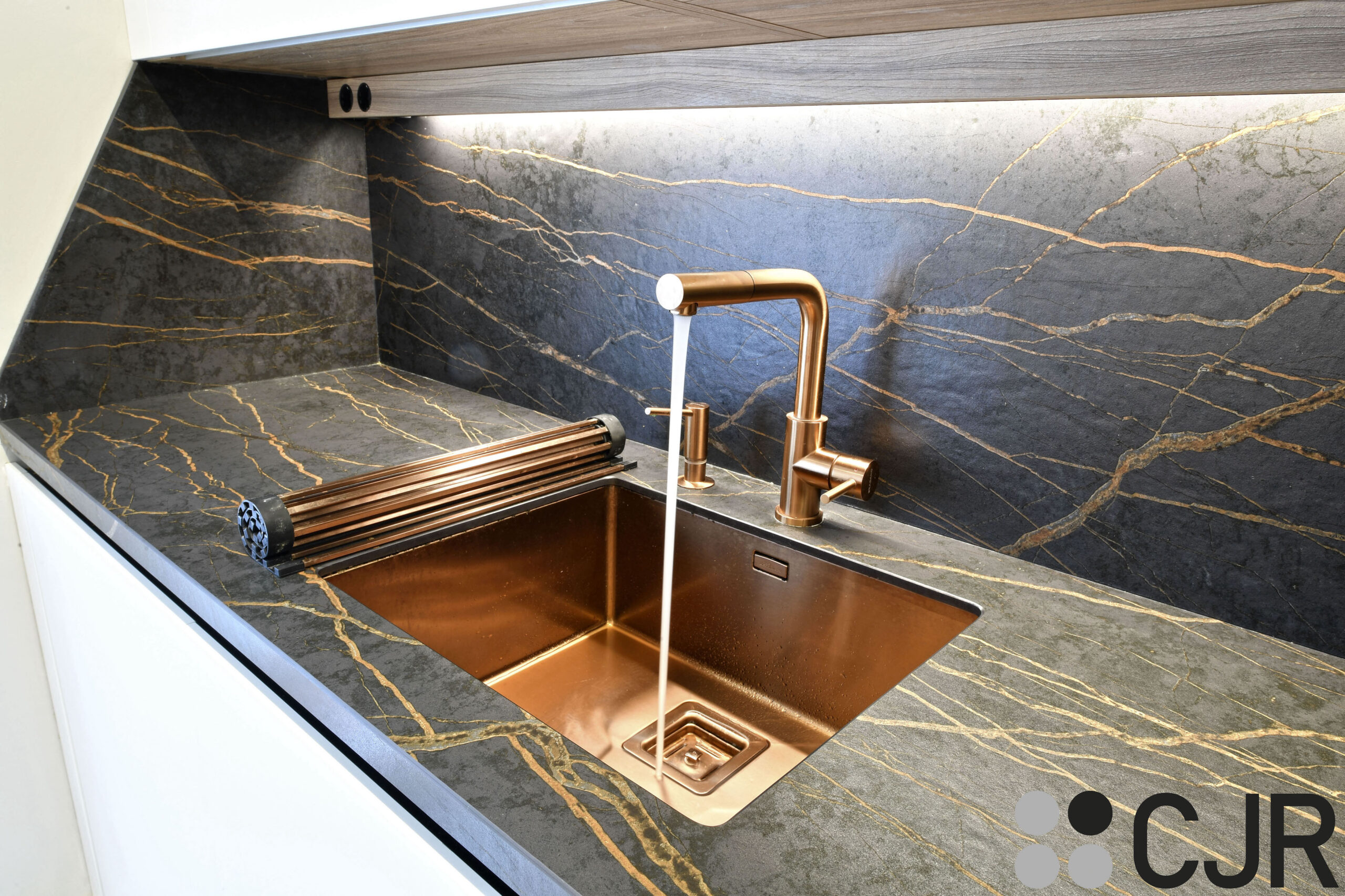 grifo fregadero dosificador y rollup en cobre de plados en encimera dekton laurent cocinas cjr