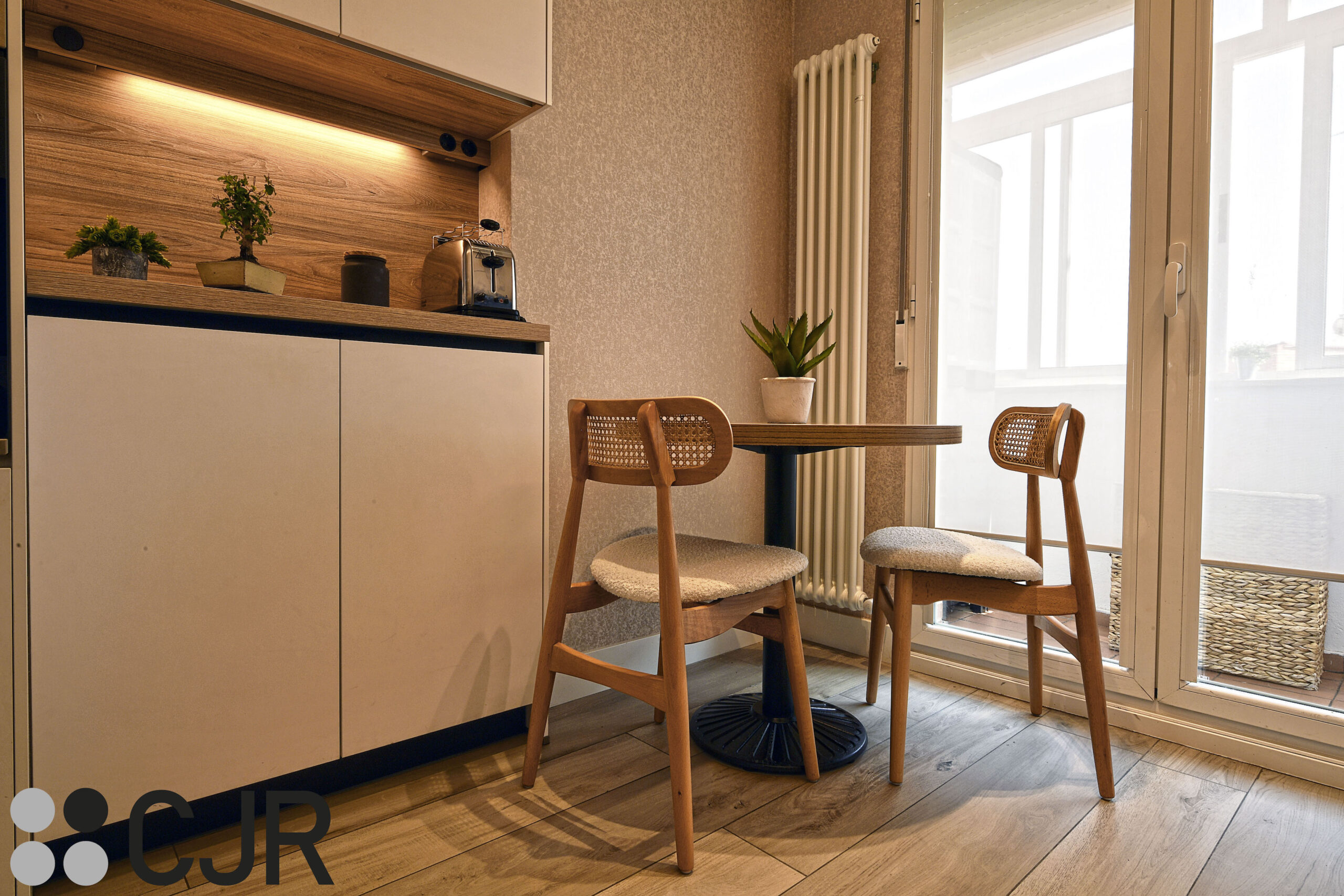 mesa de cocina en zona de office en cocina blanca y madera sillas singular market cocinas cjr
