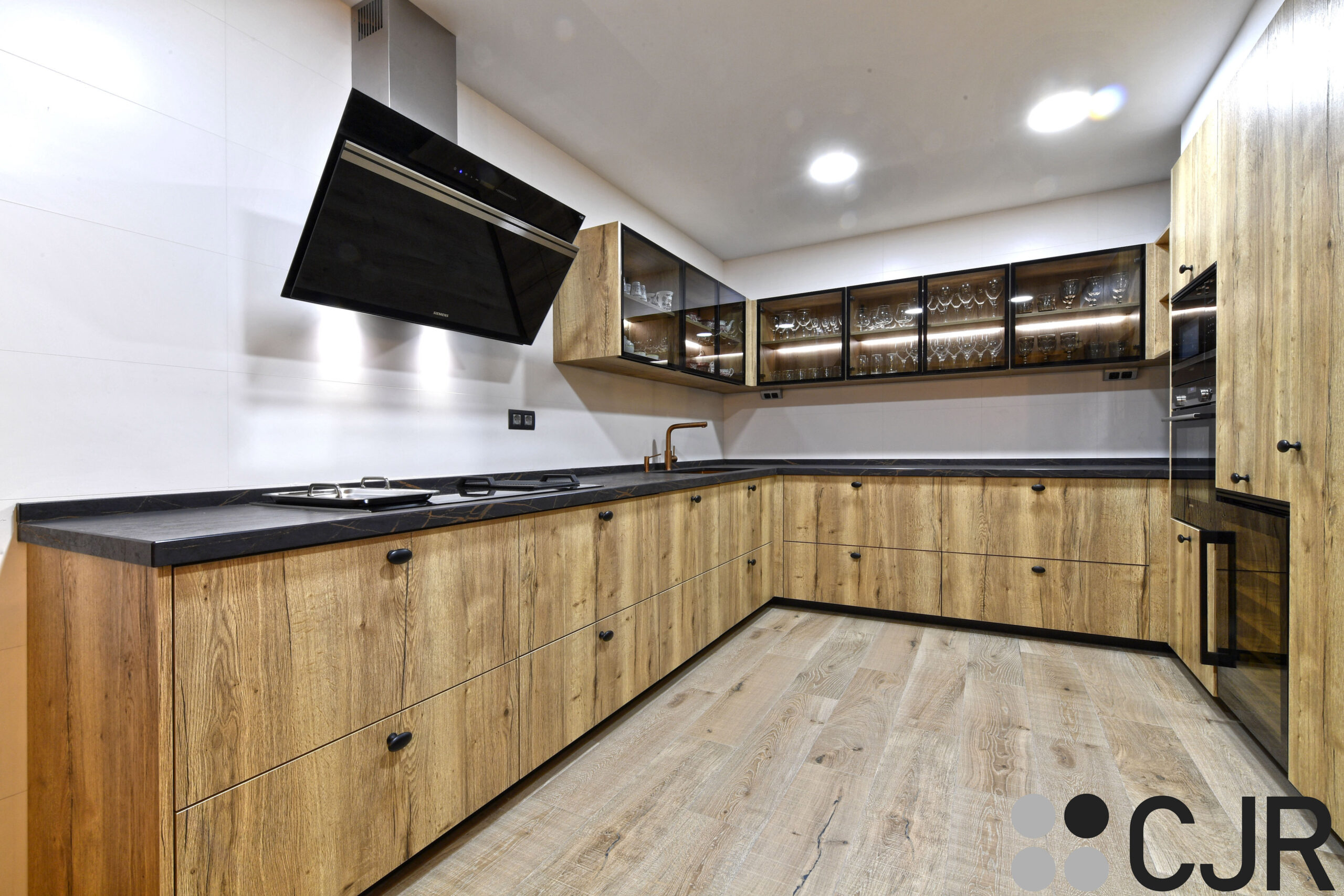 Cocinas abiertas negras y madera con barra y vitrinas en bodega cocinas CJR