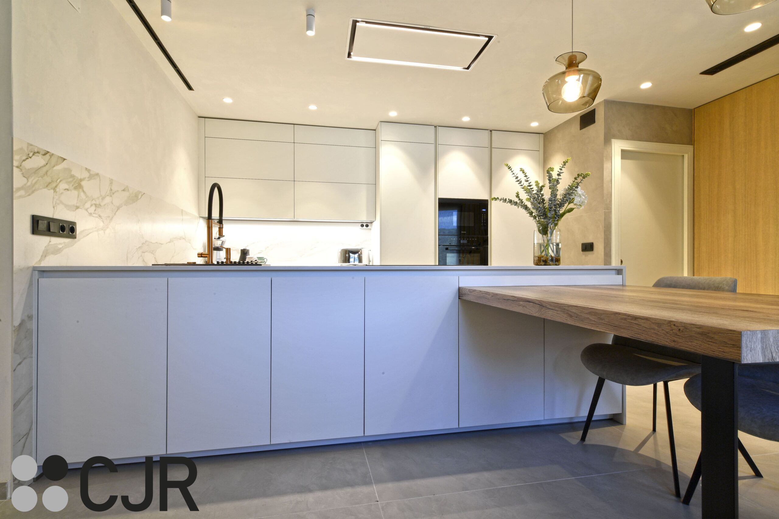 cocina blanca moderna con peninsula y mesa cocinas cjr lorena dominguez interiorismo