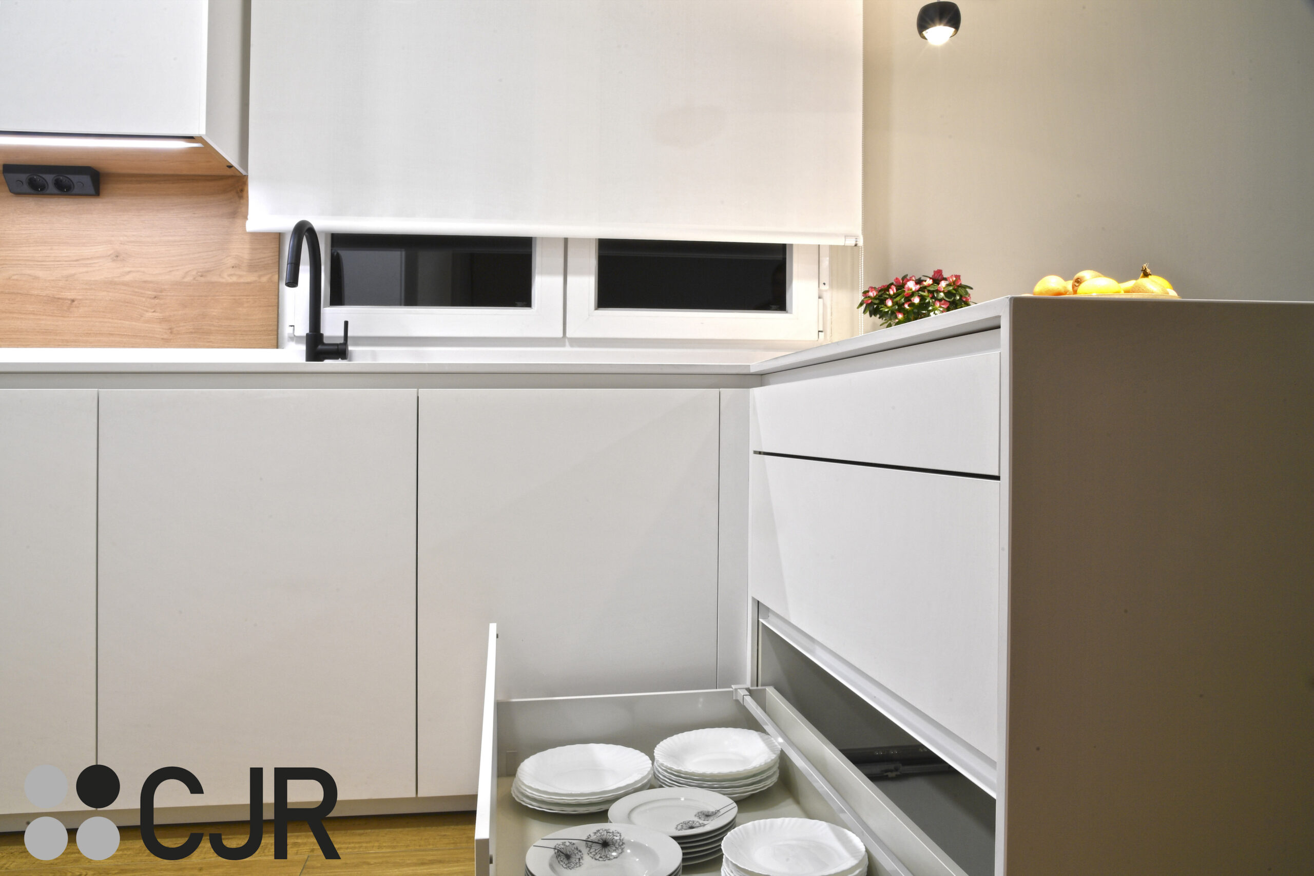 mueble bajo con separador de tapas de cocina blanca y madera abierta con peninsula cocinas cjr