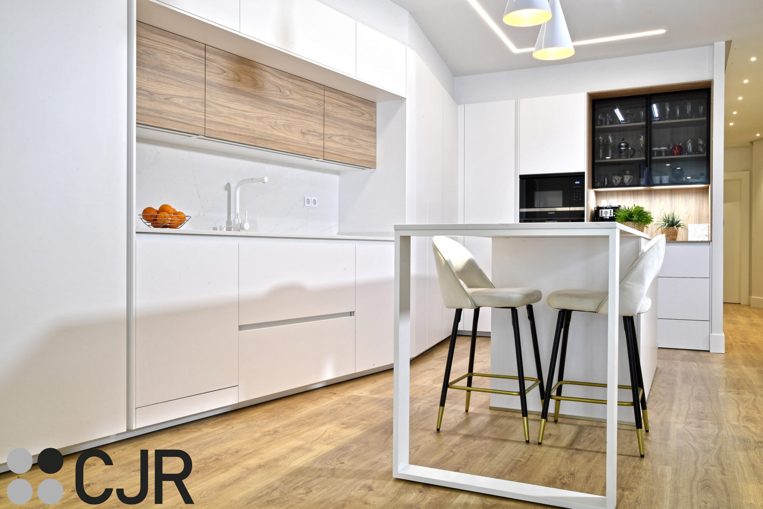 barra en cocina blanca y madera abierta al salon con isla Cocinas CJR