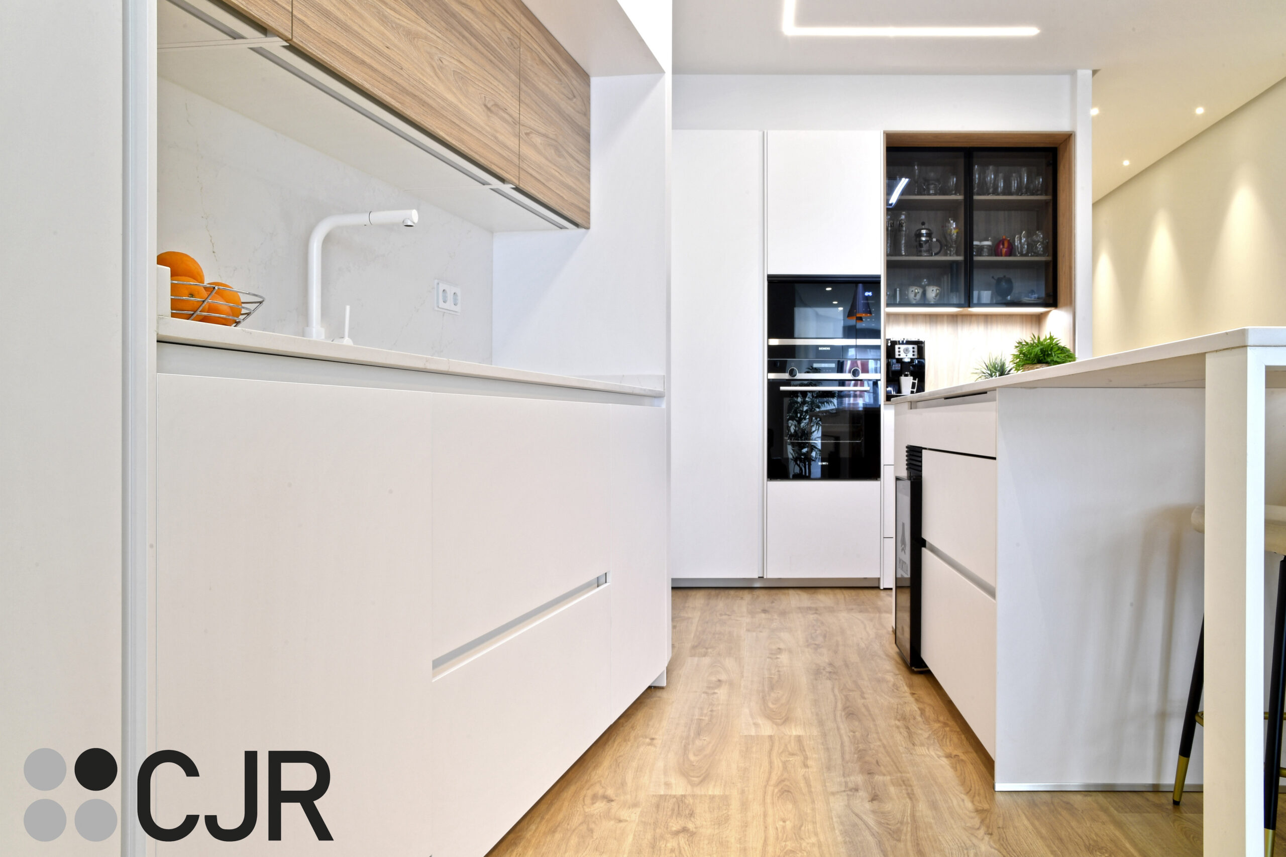 cocina blanca y madera abierta al salon con isla Cocinas CJR