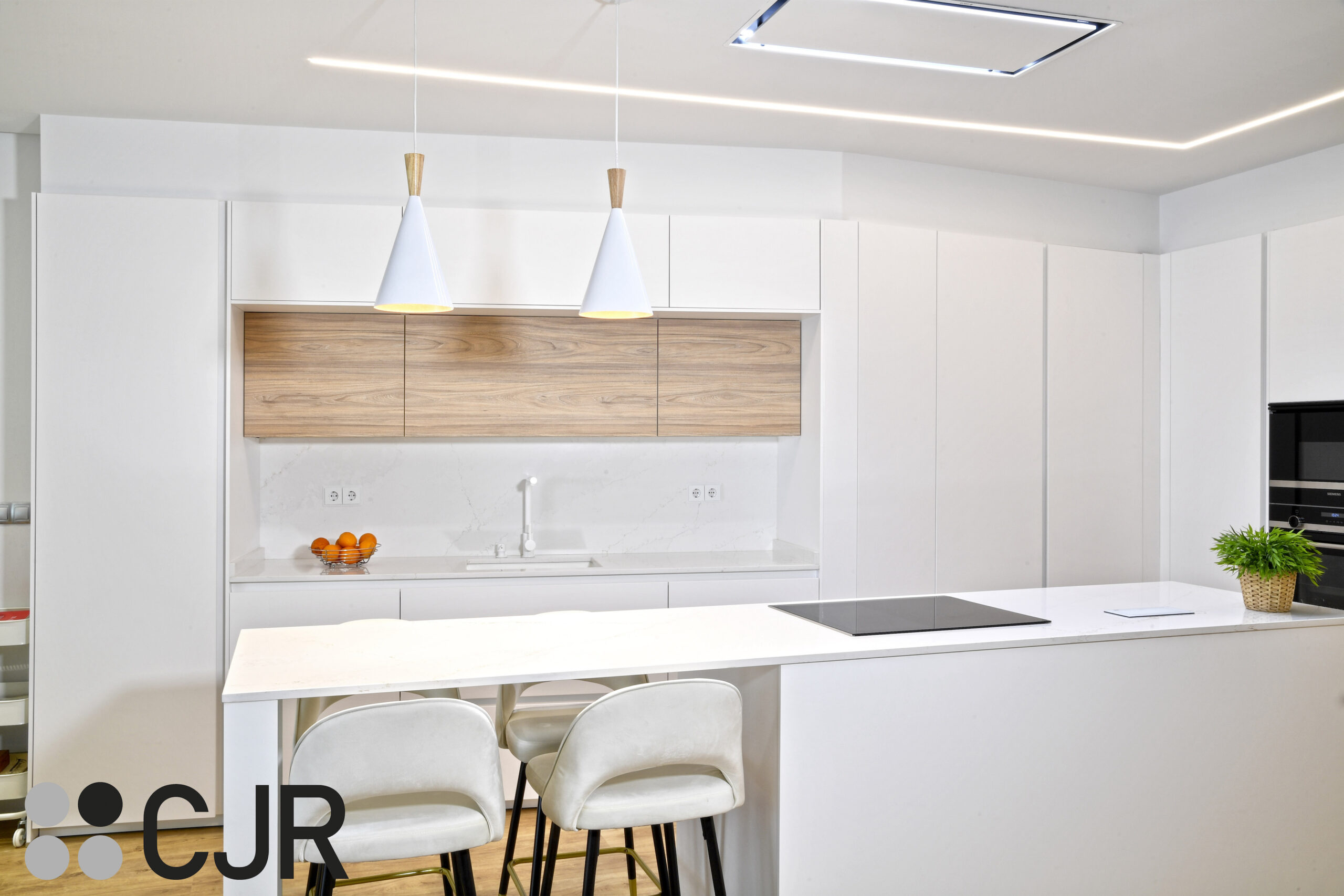 cocina con isla blanca y madera abierta al salon Cocinas CJR