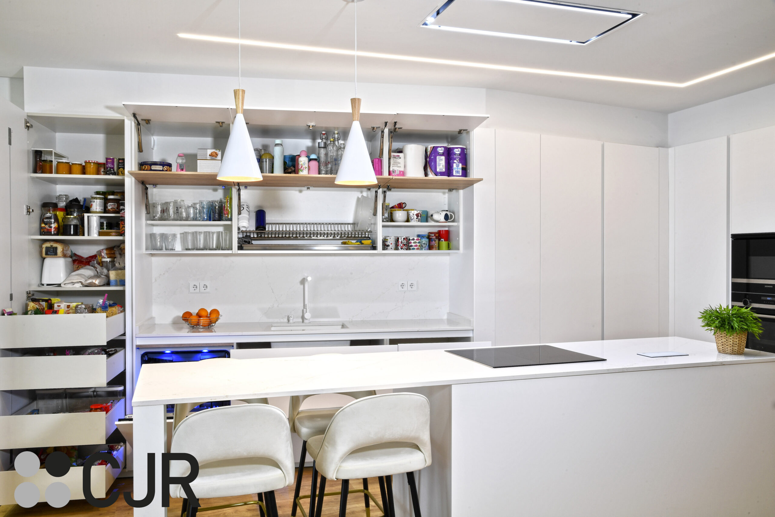 cocina puente en cocina blanca y madera abierta al salon con isla Cocinas CJR