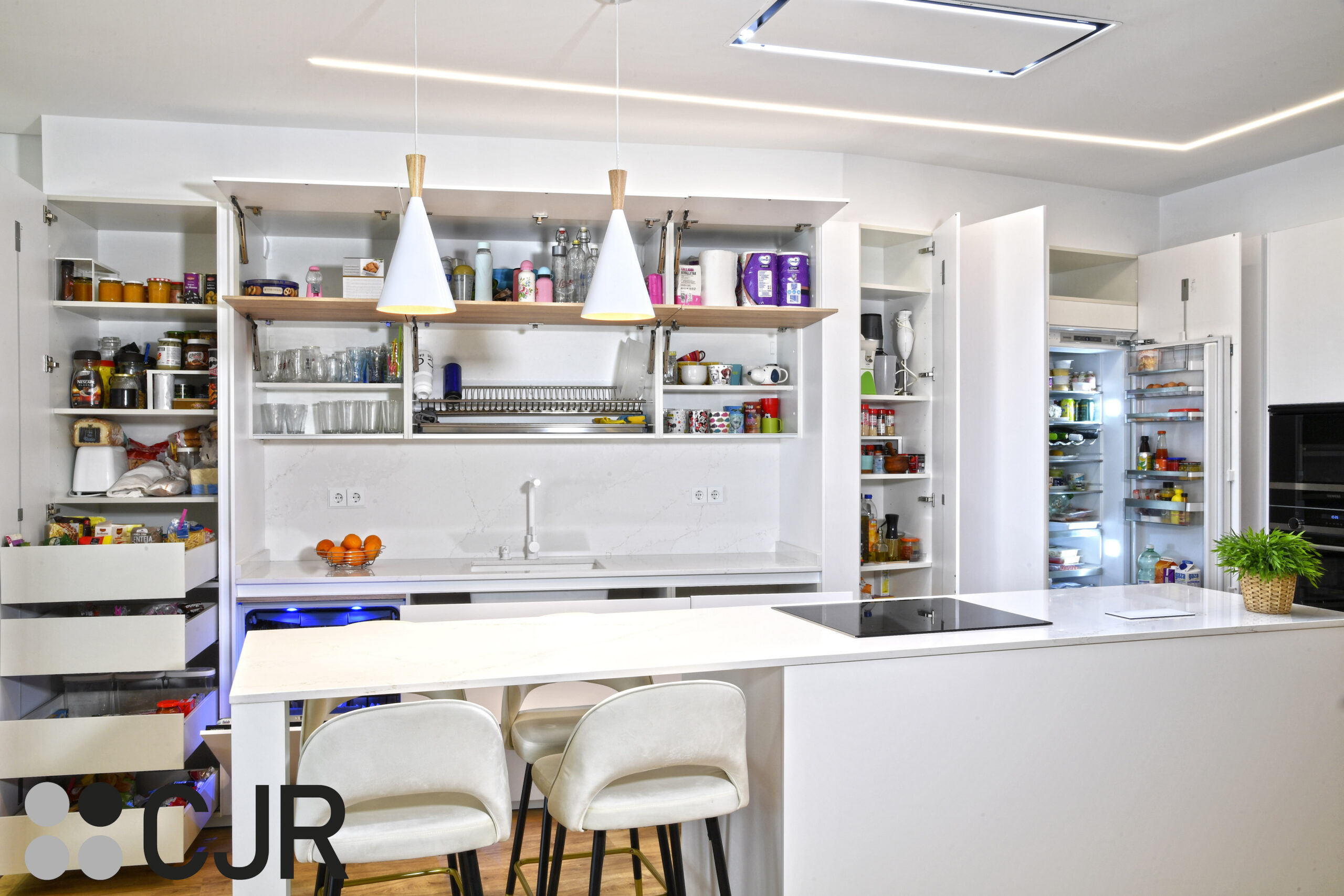 frigorifico y congelador integrado en cocina blanca y madera abierta al salon con isla Cocinas CJR