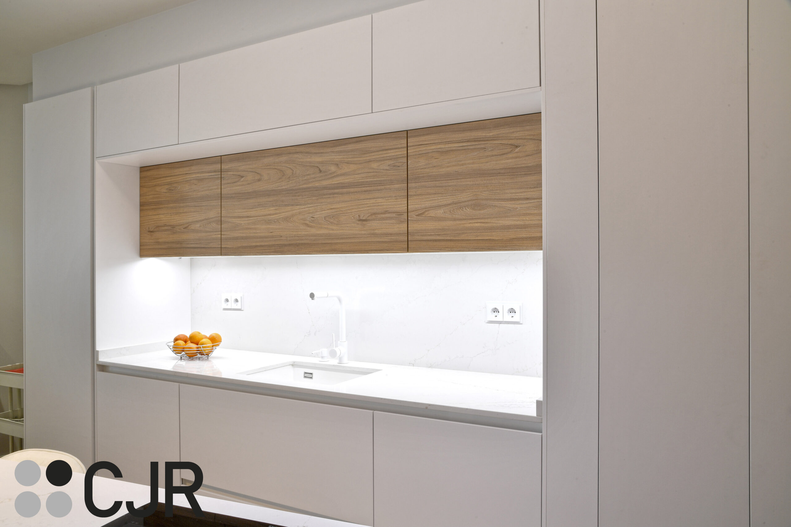 iluminacion de cocina blanca y madera abierta al salon con isla Cocinas CJR