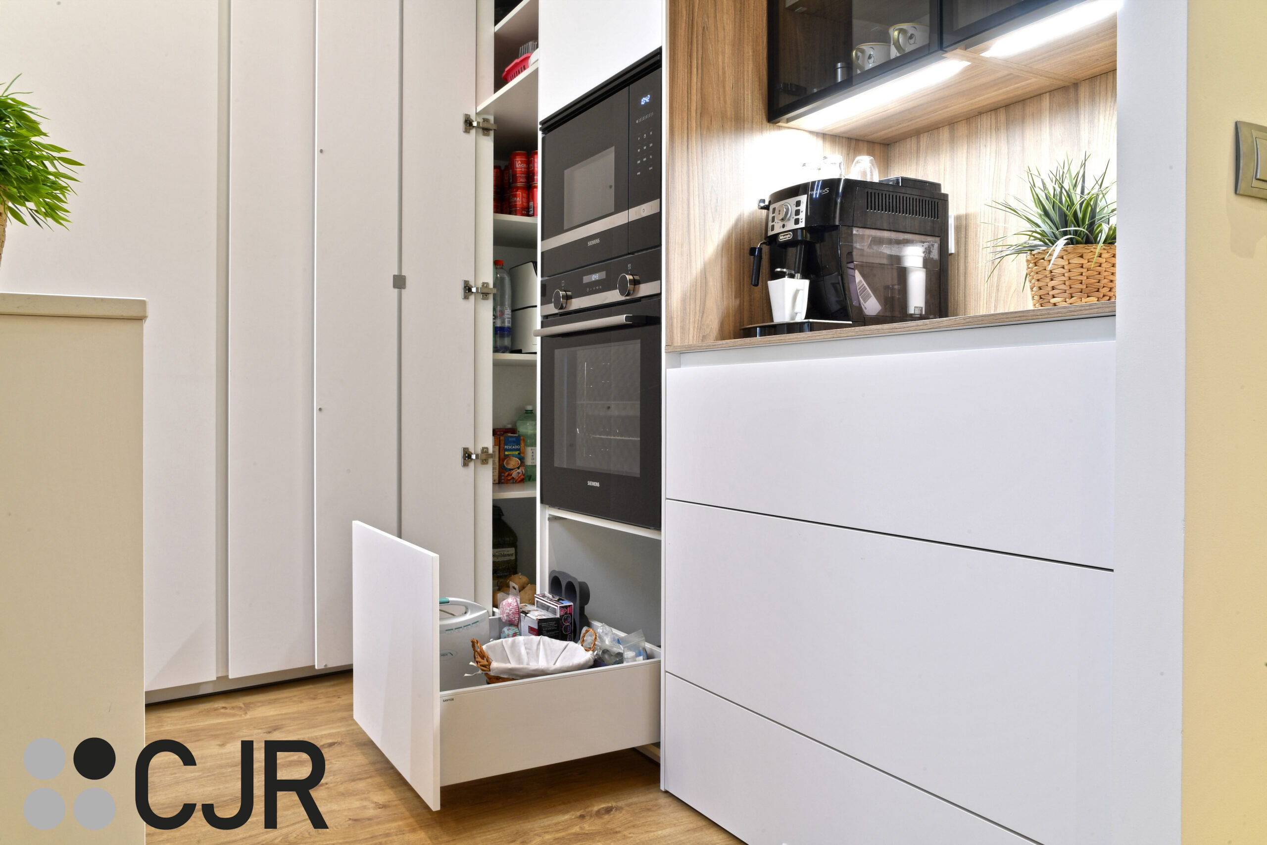 mueble bajo en torre de horno y microondas en cocina blanca y madera abierta al salon con isla Cocinas CJR