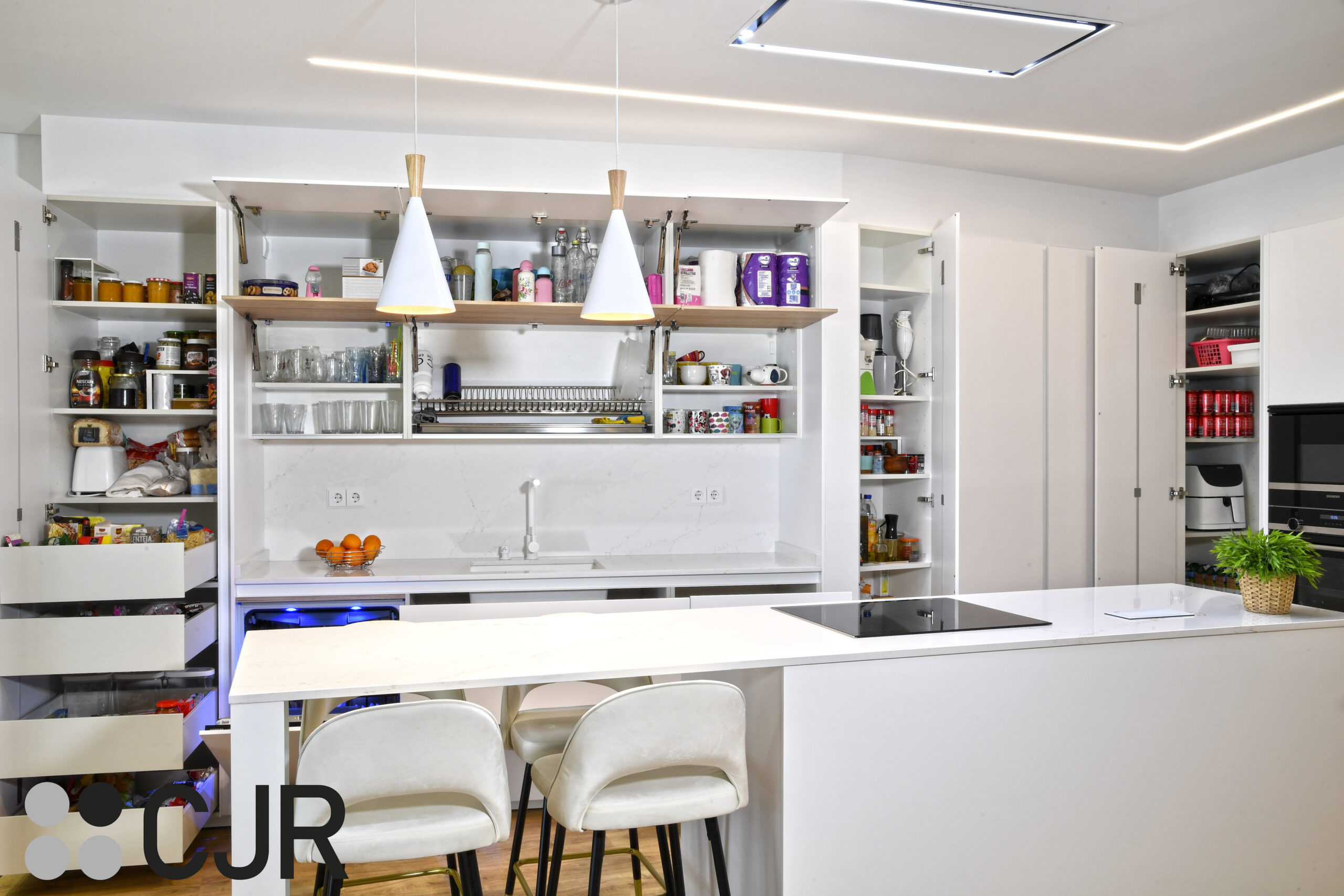 mueble en esquina en cocina blanca y madera abierta al salon con isla Cocinas CJR