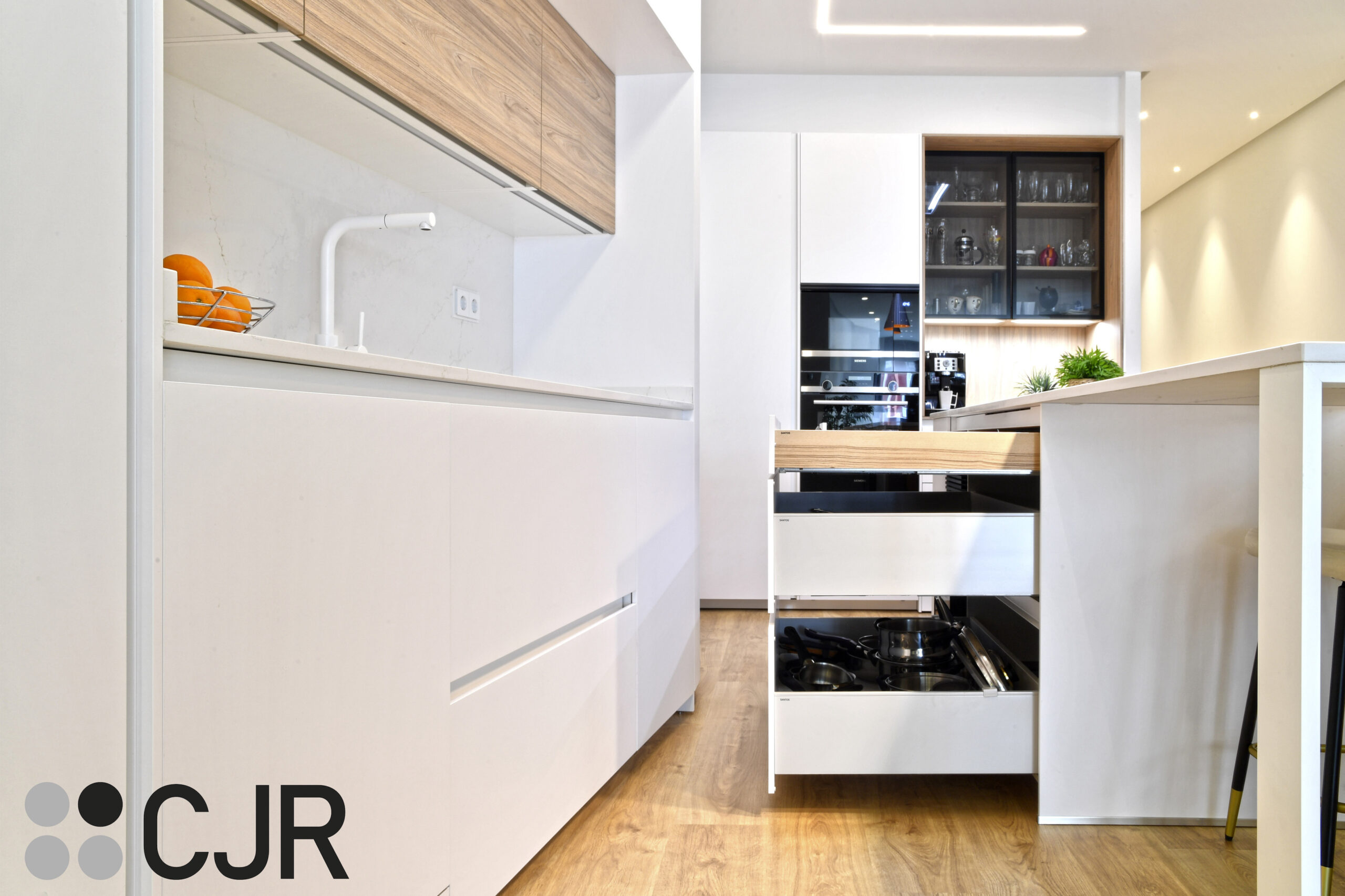 muebles bajos en cocina blanca y madera abierta al salon con isla Cocinas CJR
