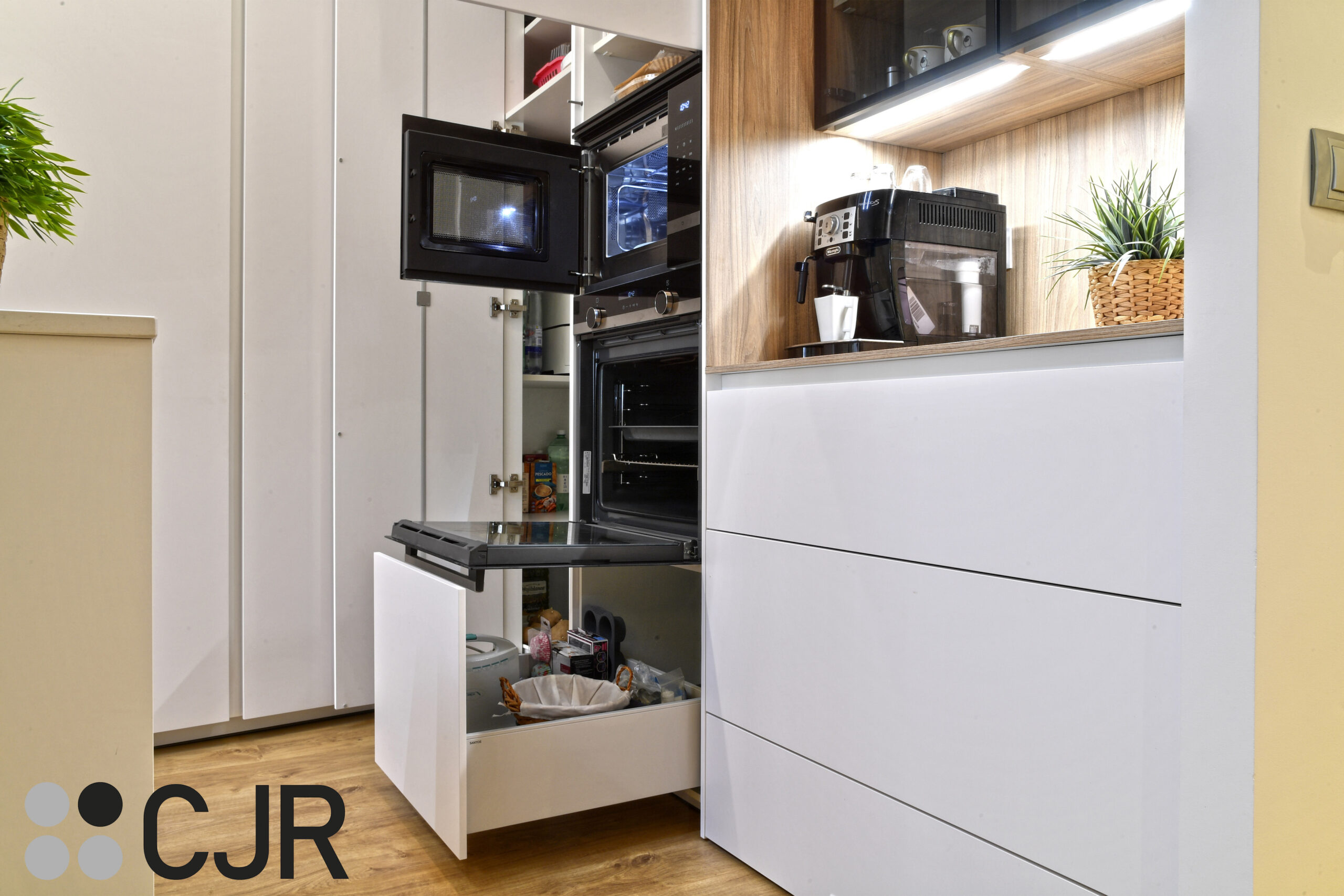 torre de horno y microondas en cocina blanca y madera abierta al salon con isla Cocinas CJR