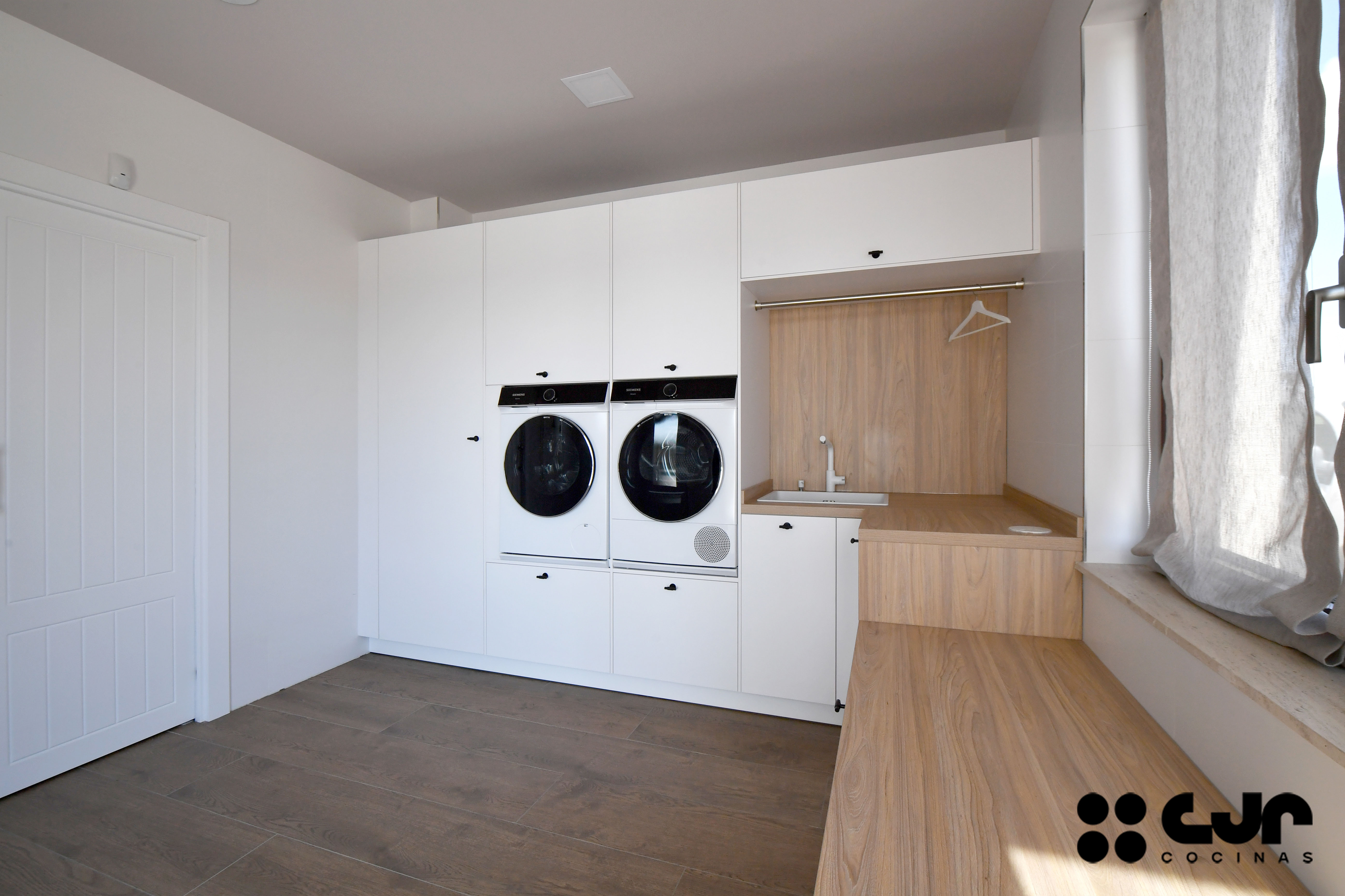 Lavandería grande en blanco y madera cocinas Cjr