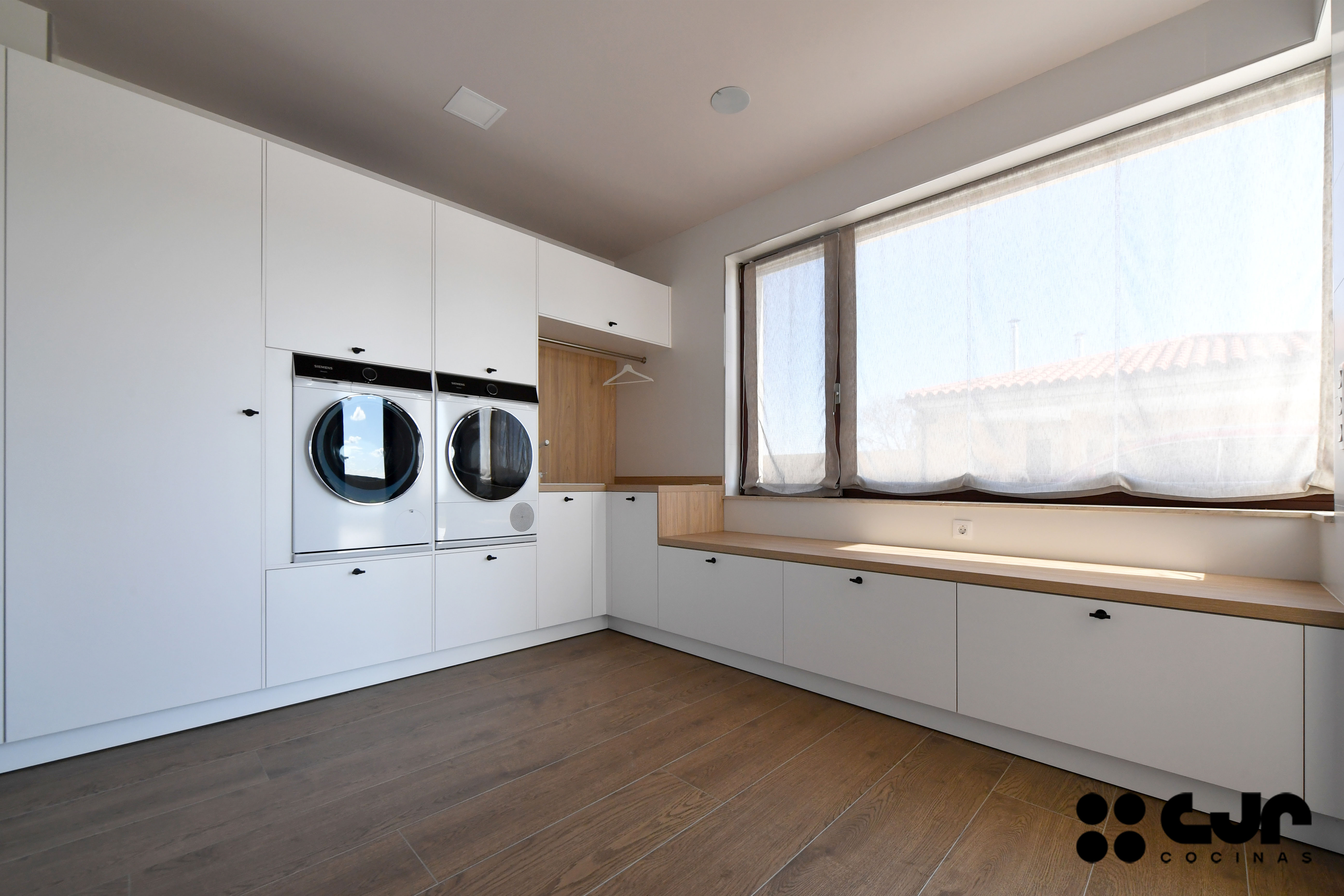 Lavandería grande en blanco y madera cocinas Cjr