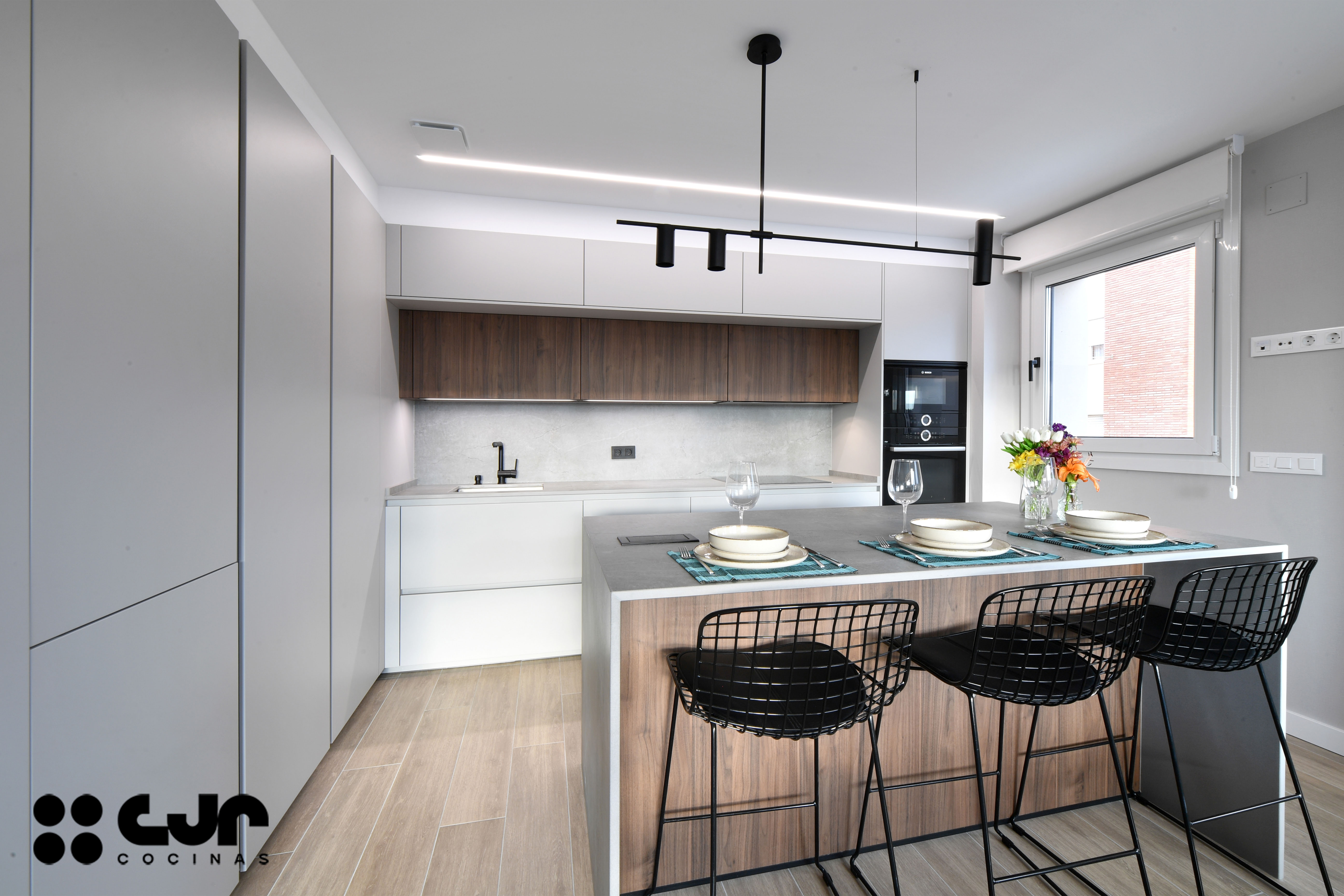 cocina abierta con isla gris y madera cocinas cjr
