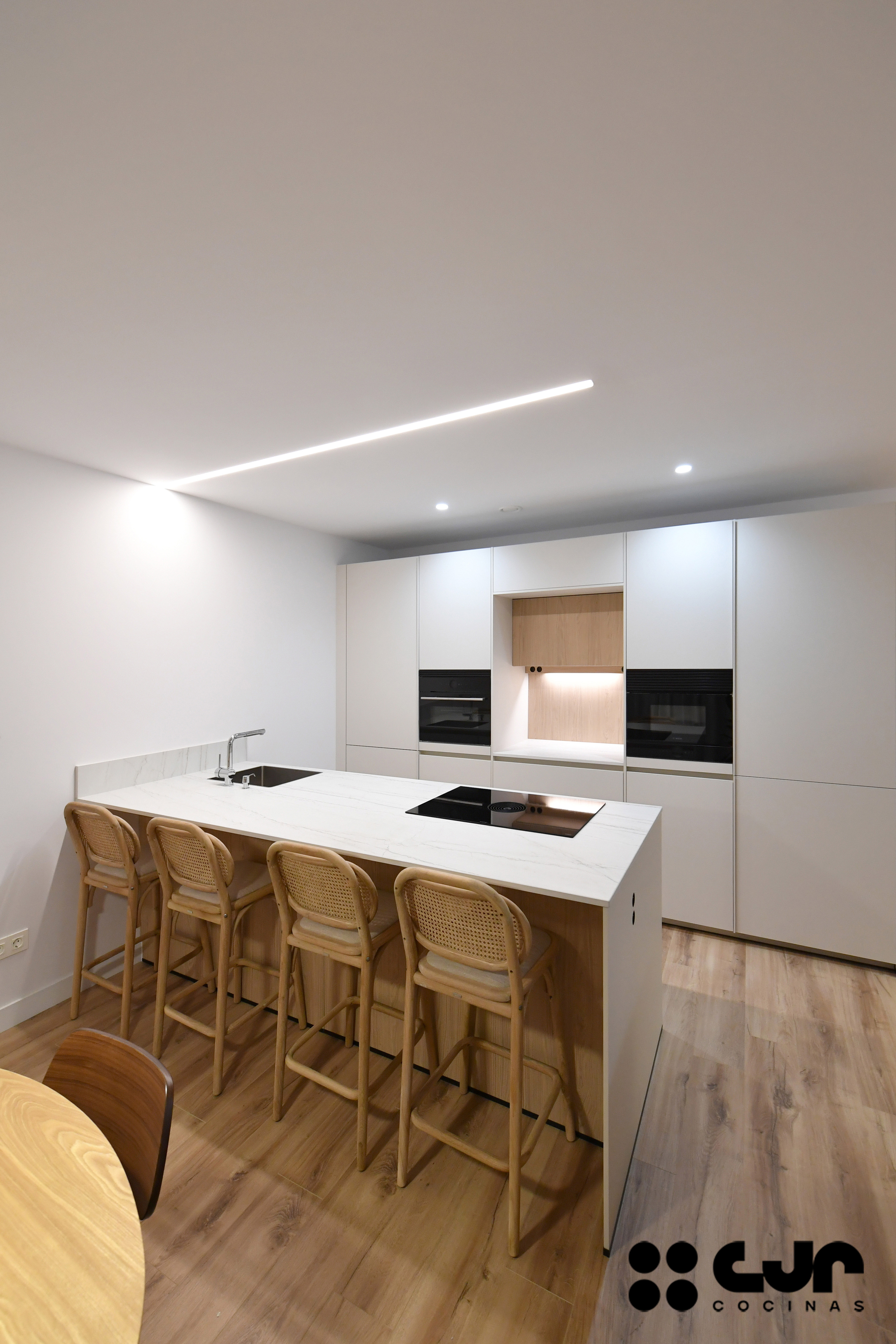 cocina blanca y madera con peninsula cocinas cjr