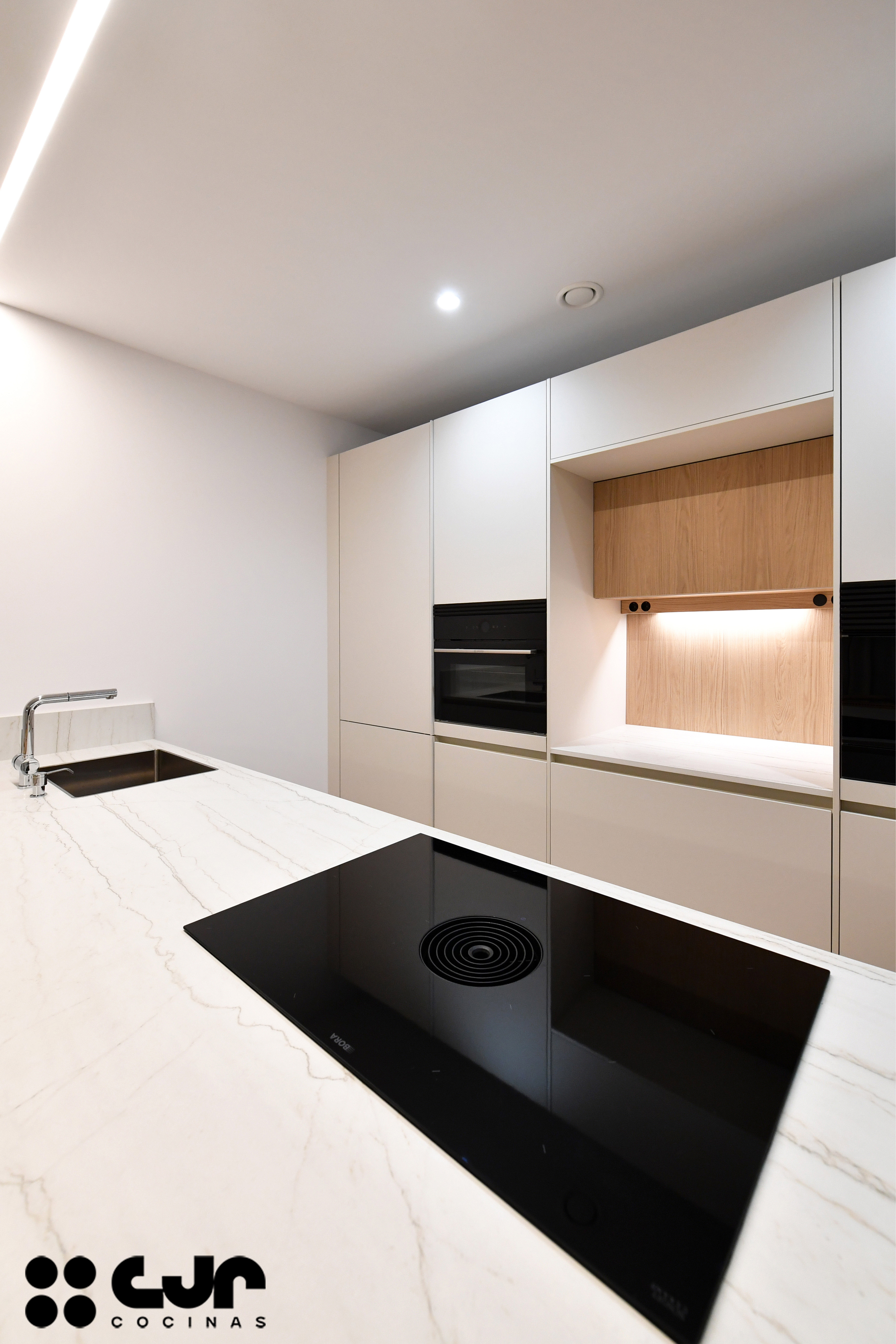 cocina blanca y madera con peninsula cocinas cjr