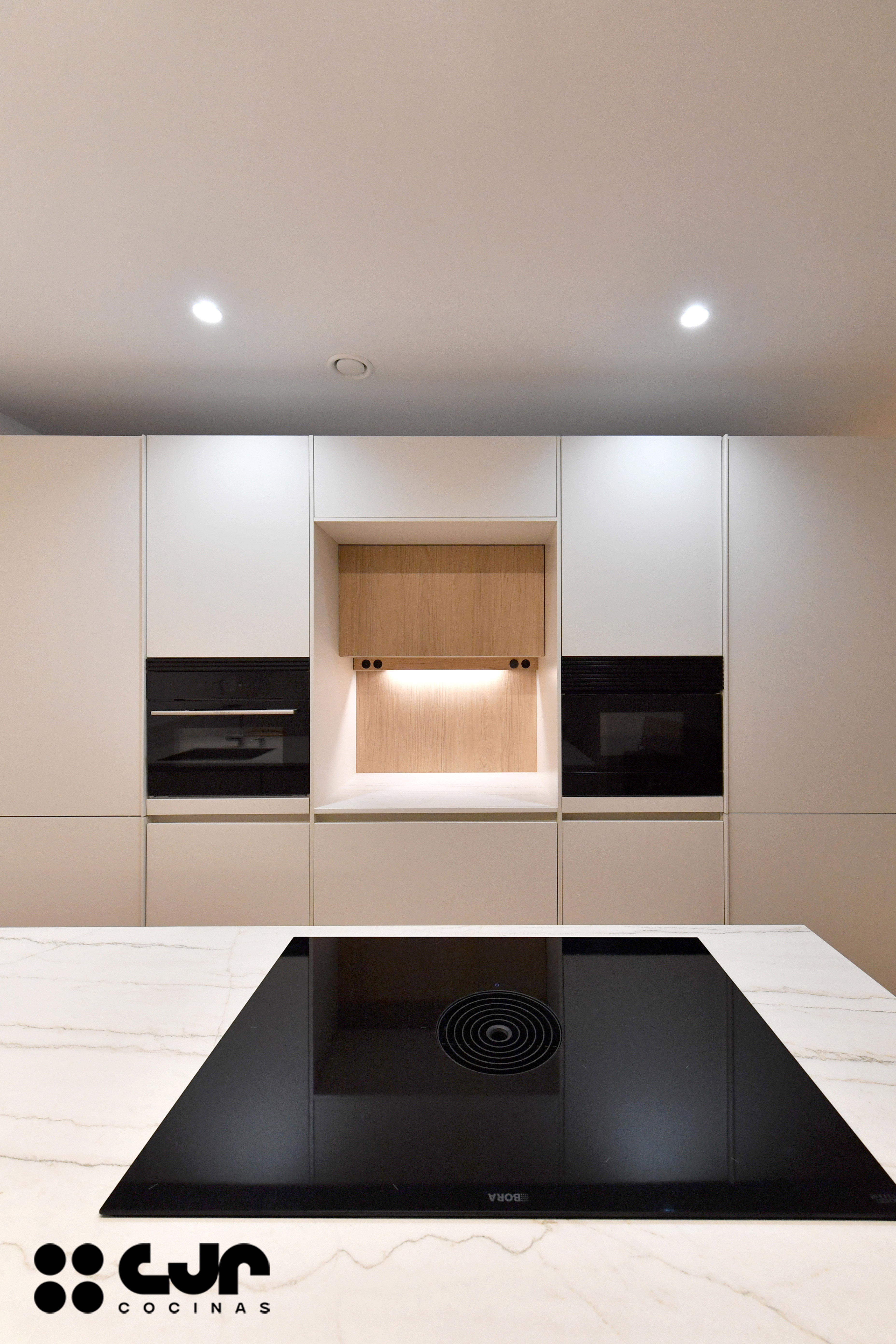 cocina blanca y madera con peninsula cocinas cjr