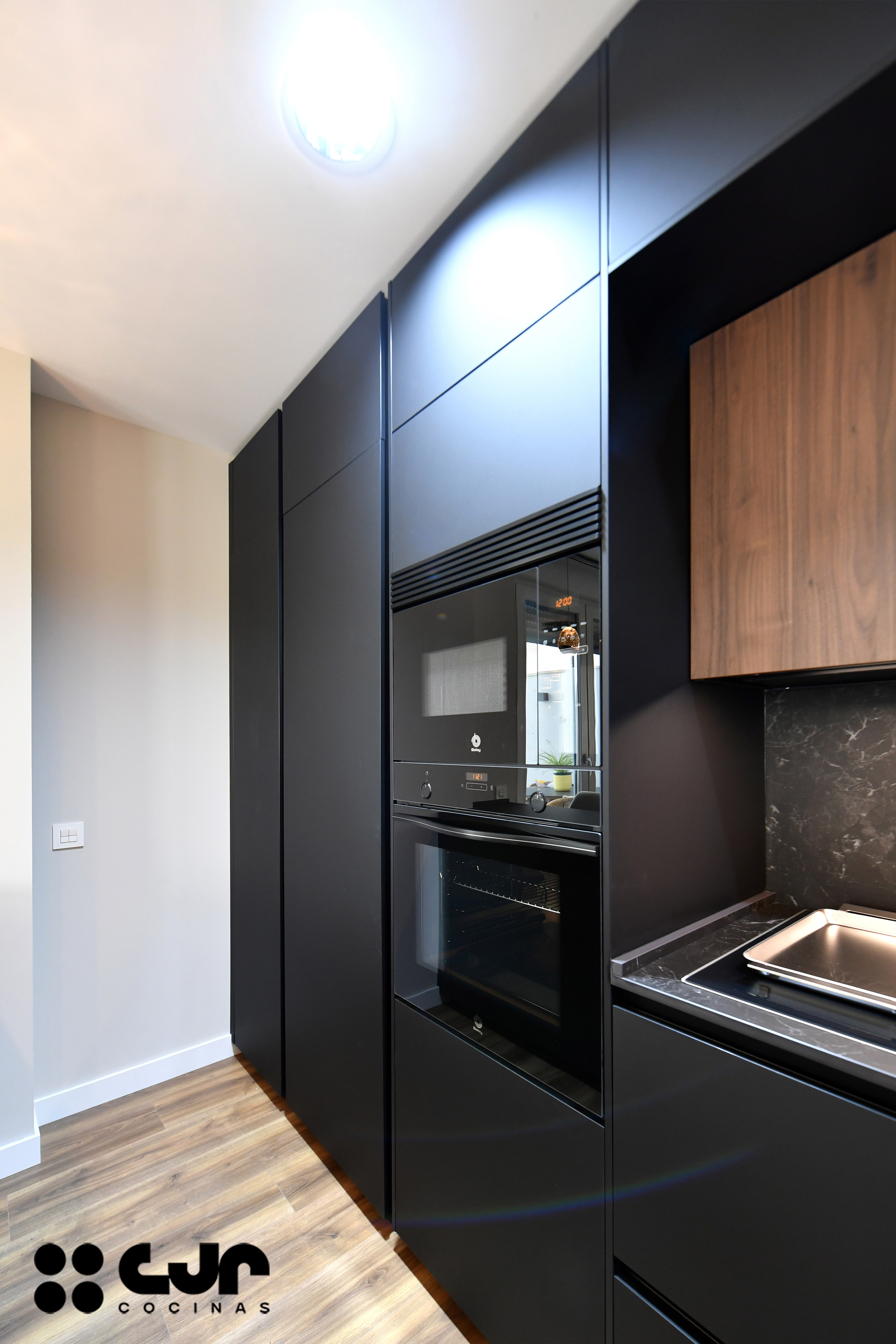 cocina negra y madera abierta con peninsula cocinas cjr