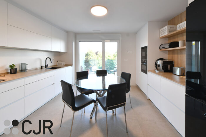 Cocina blanca y madera en dos frentes con mesa cocinas cjr