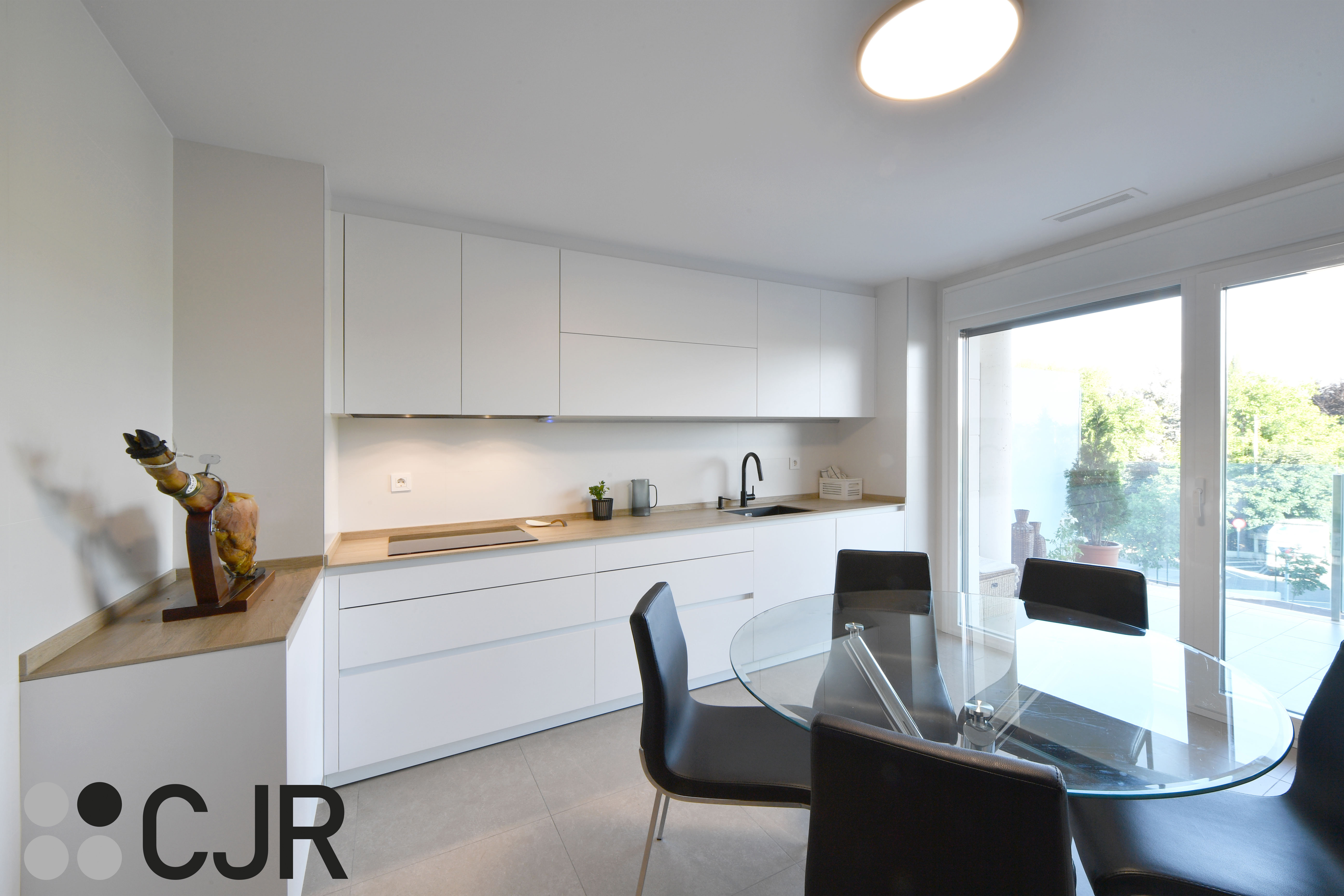 Cocina blanca y madera en dos frentes con mesa cocinas cjr