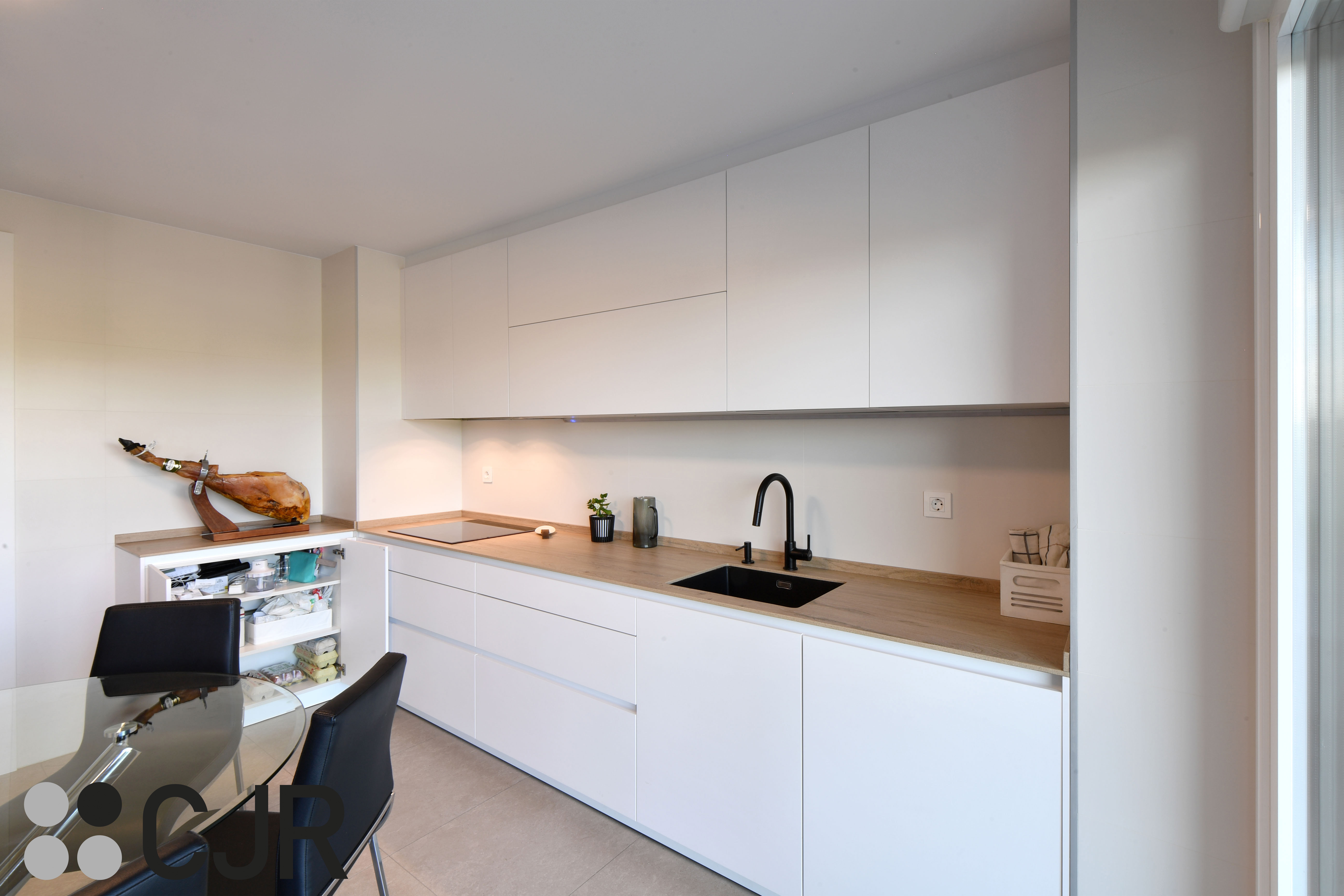 Cocina blanca y madera en dos frentes con mesa cocinas cjr