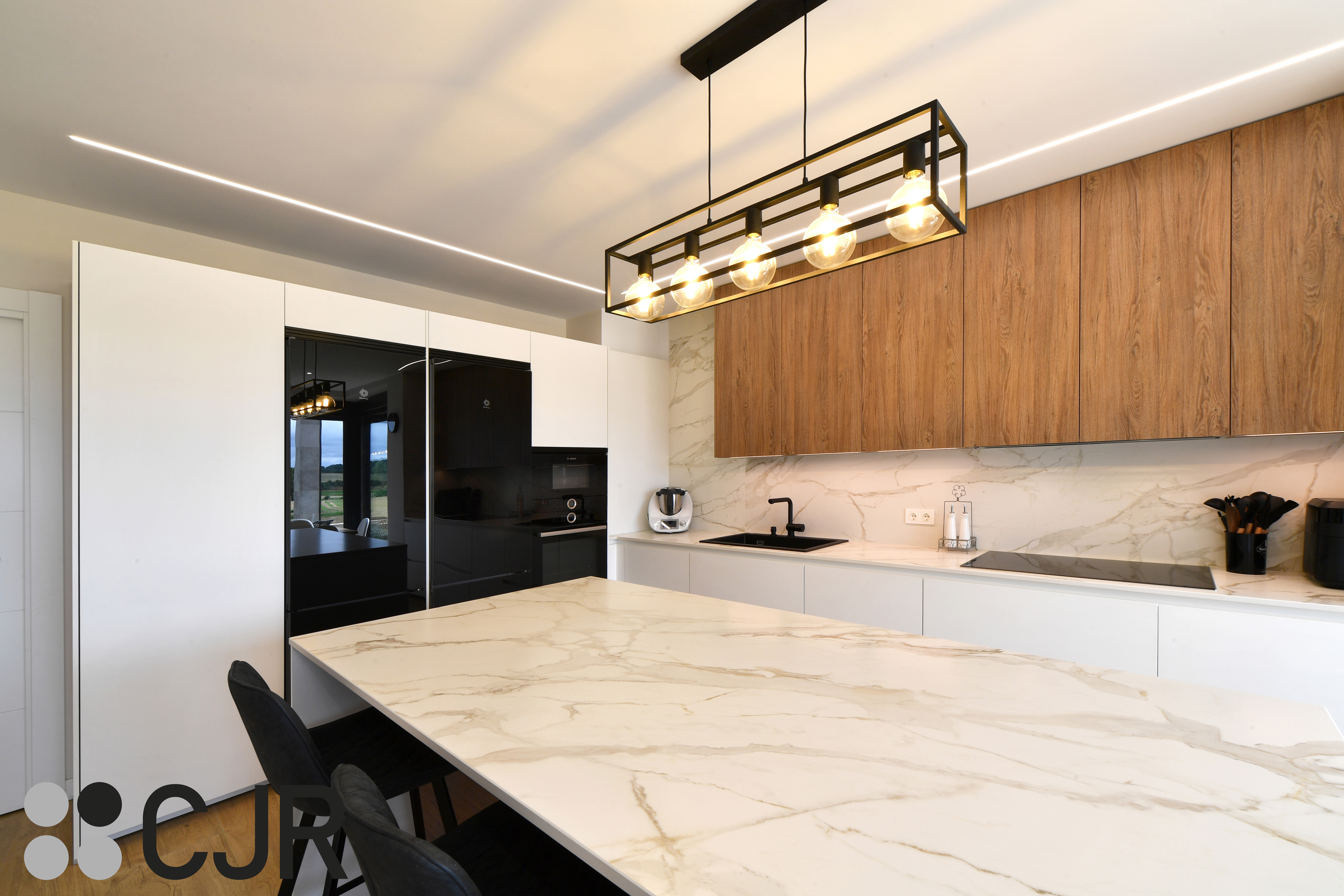 Cocina moderna blanca y madera con isla central y mesa Cocinas CJR