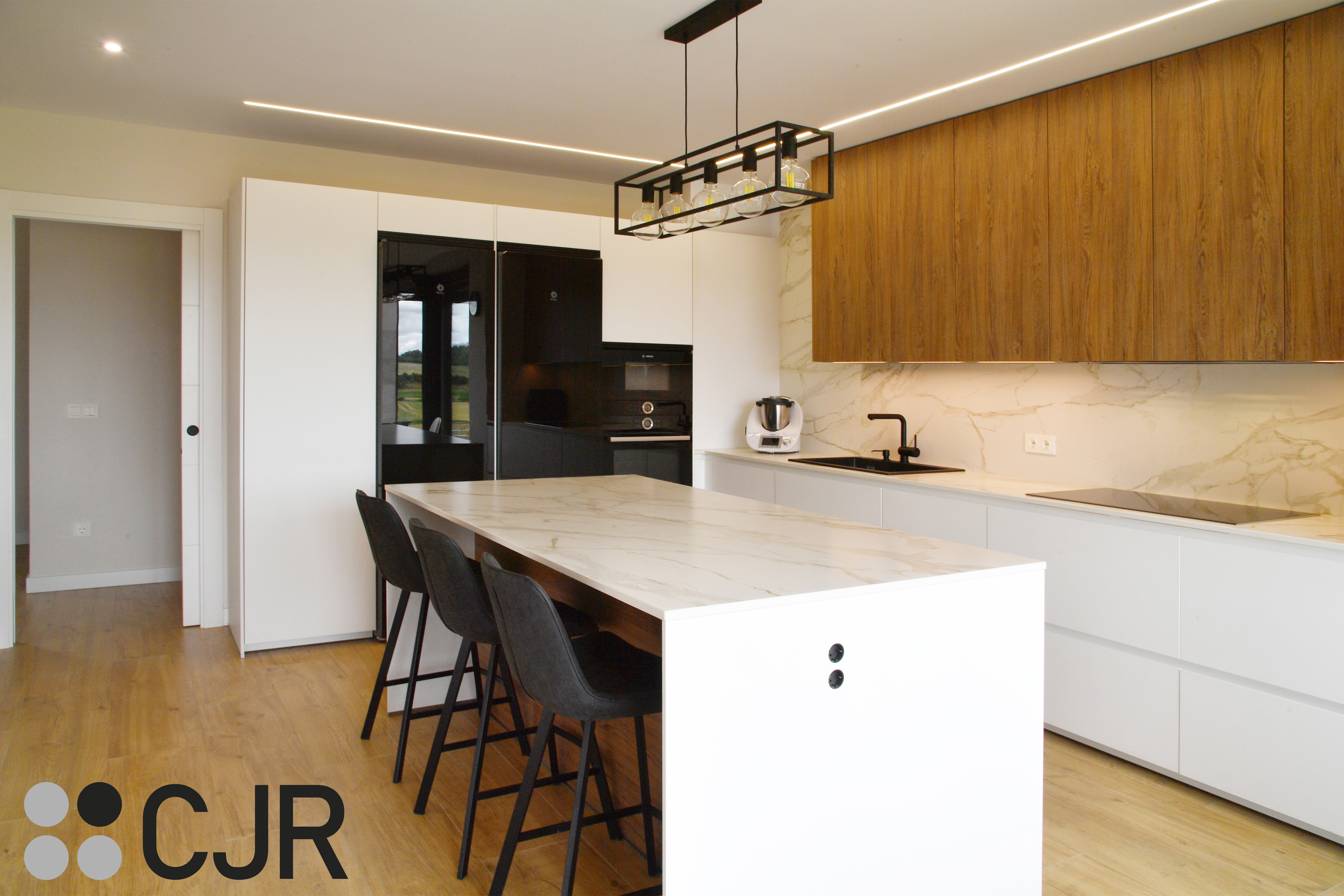 Cocina moderna blanca y madera con isla central y mesa Cocinas CJR
