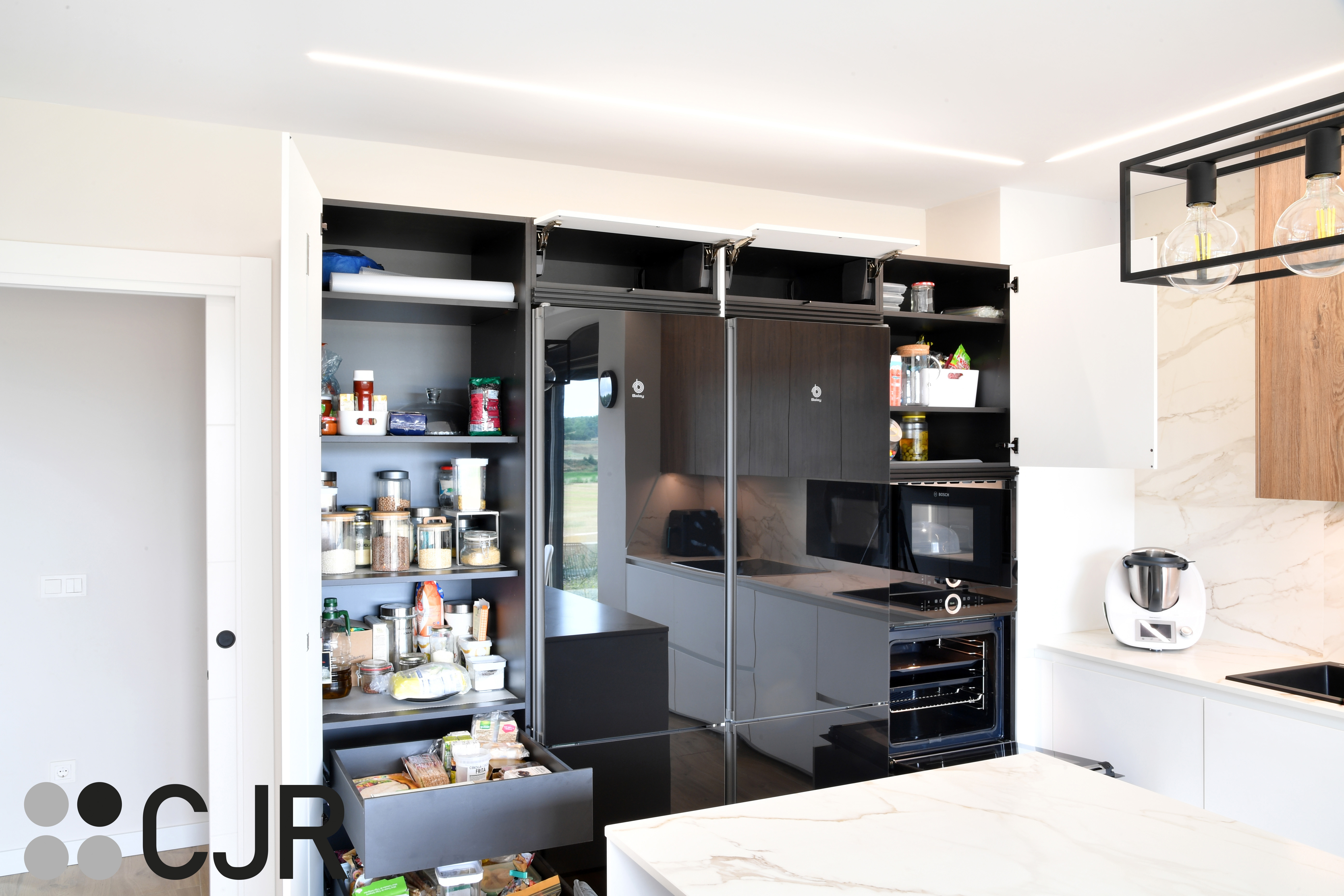 Cocina moderna blanca y madera con isla central y mesa Cocinas CJR