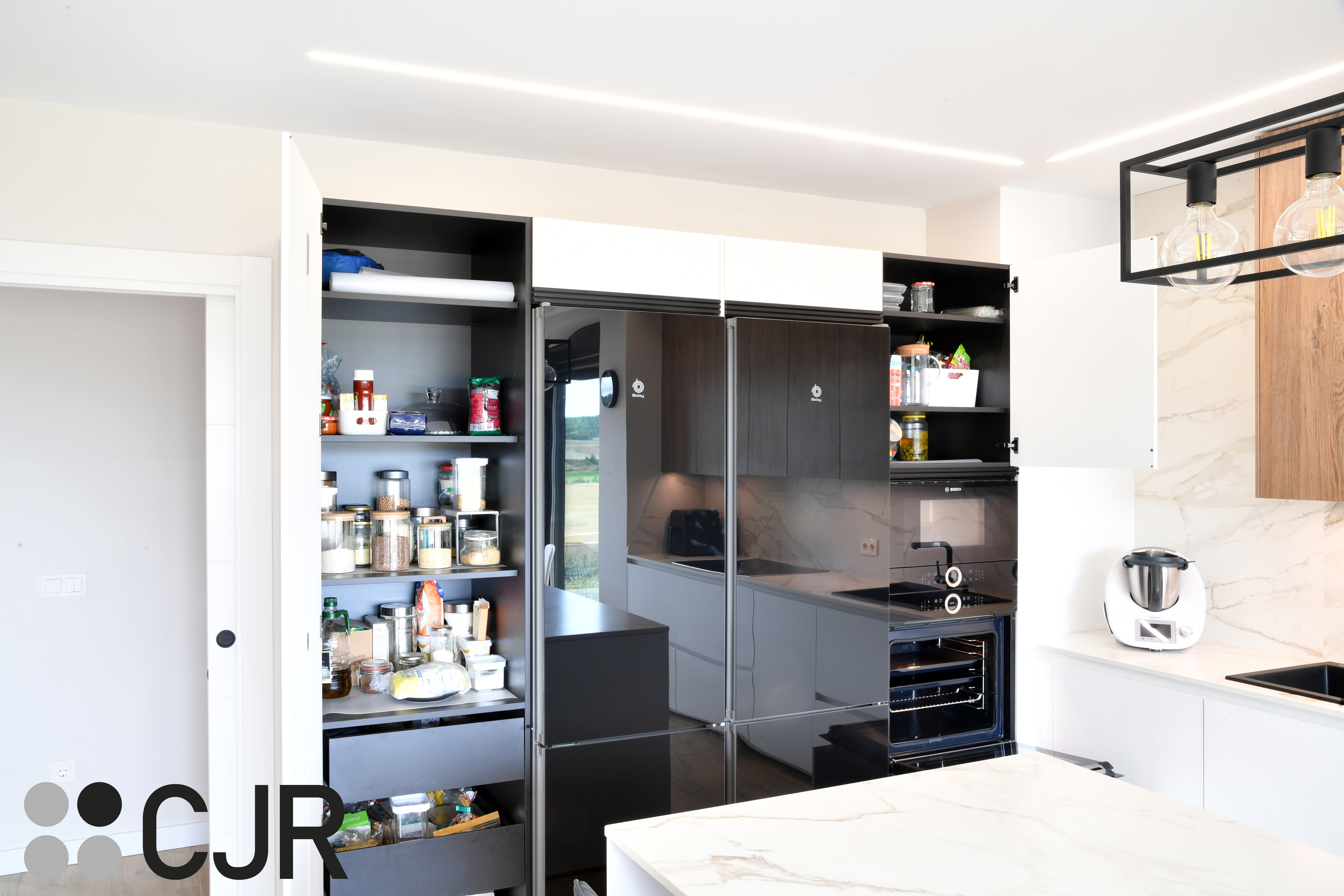 Cocina moderna blanca y madera con isla central y mesa Cocinas CJR