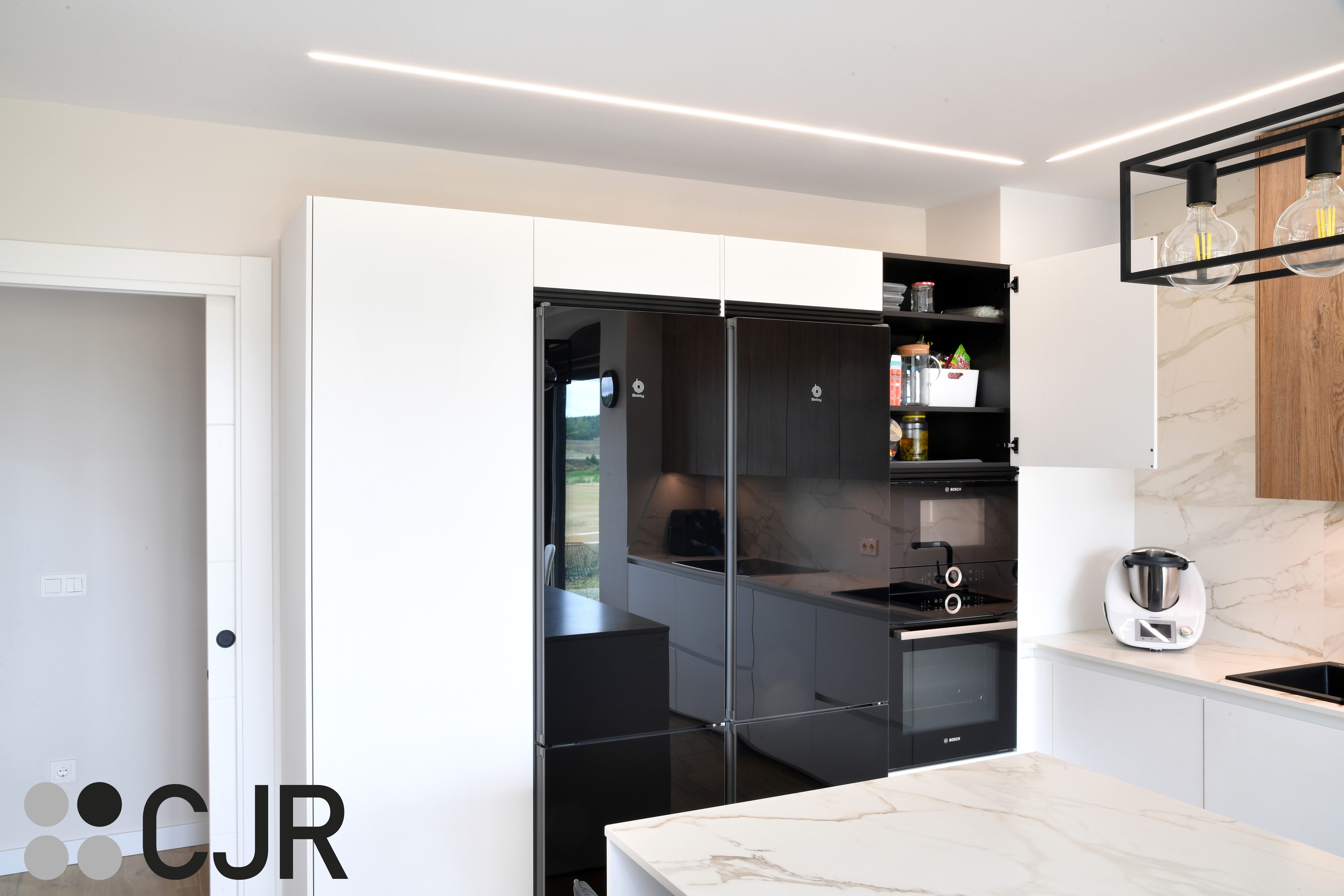 Cocina moderna blanca y madera con isla central y mesa Cocinas CJR