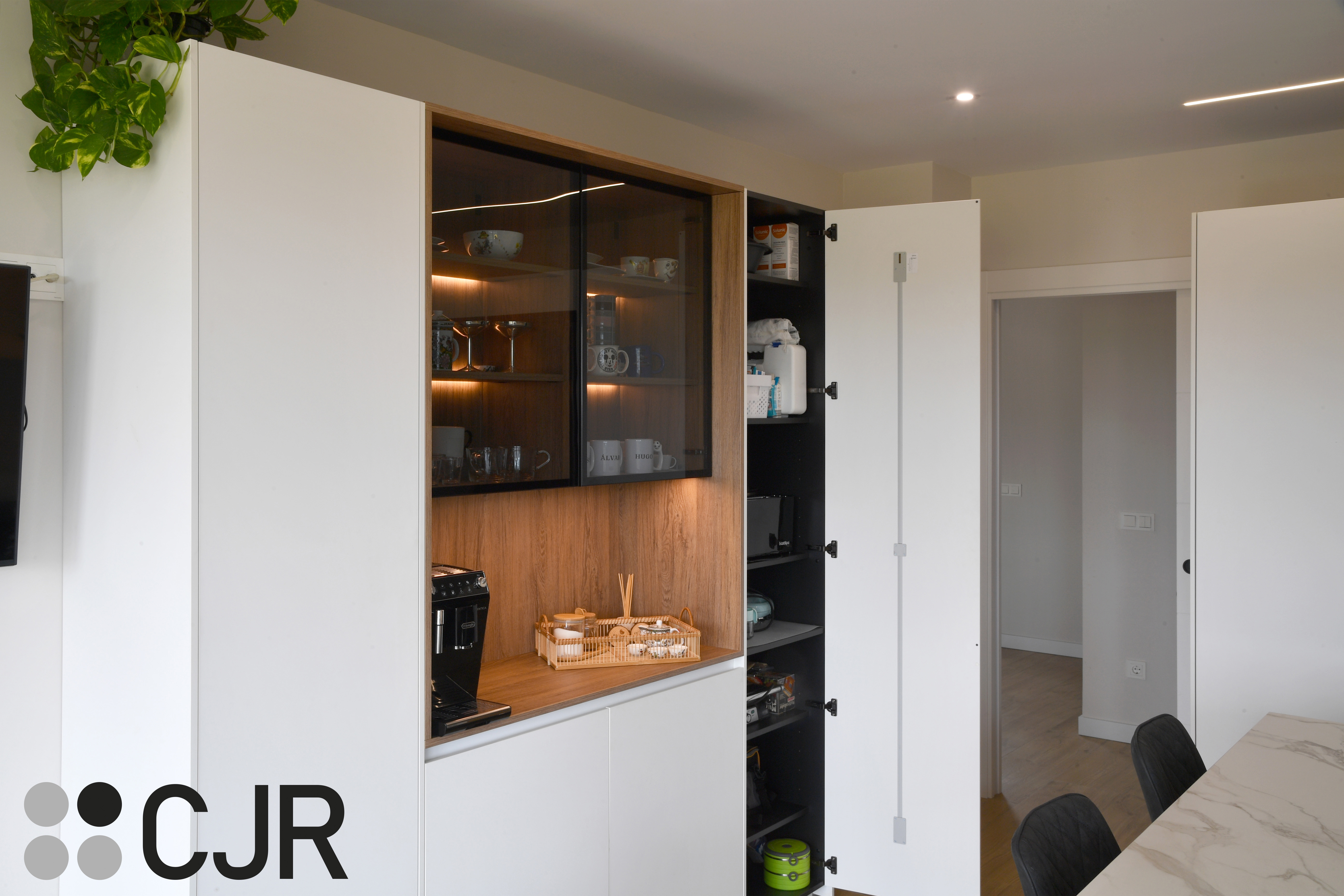 Cocina moderna blanca y madera con isla central y mesa Cocinas CJR